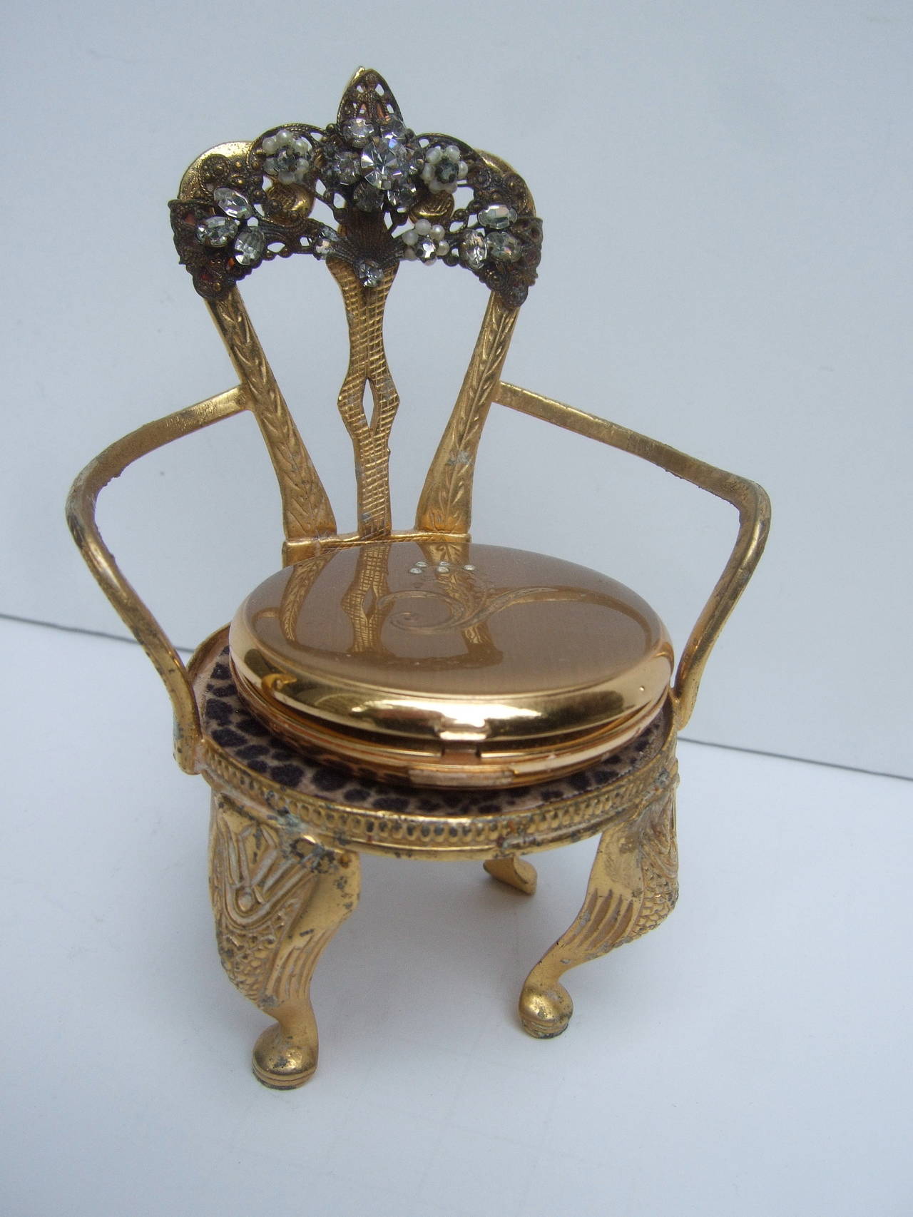Original by Robert' Rare gilt metal jeweled vanity compact chair c 1960
The unique gilt metal chair is designed with a crystal jeweled vanity 
compact that rest at the center of the chair. The ornate gilt metal 
vanity collectible is encrusted