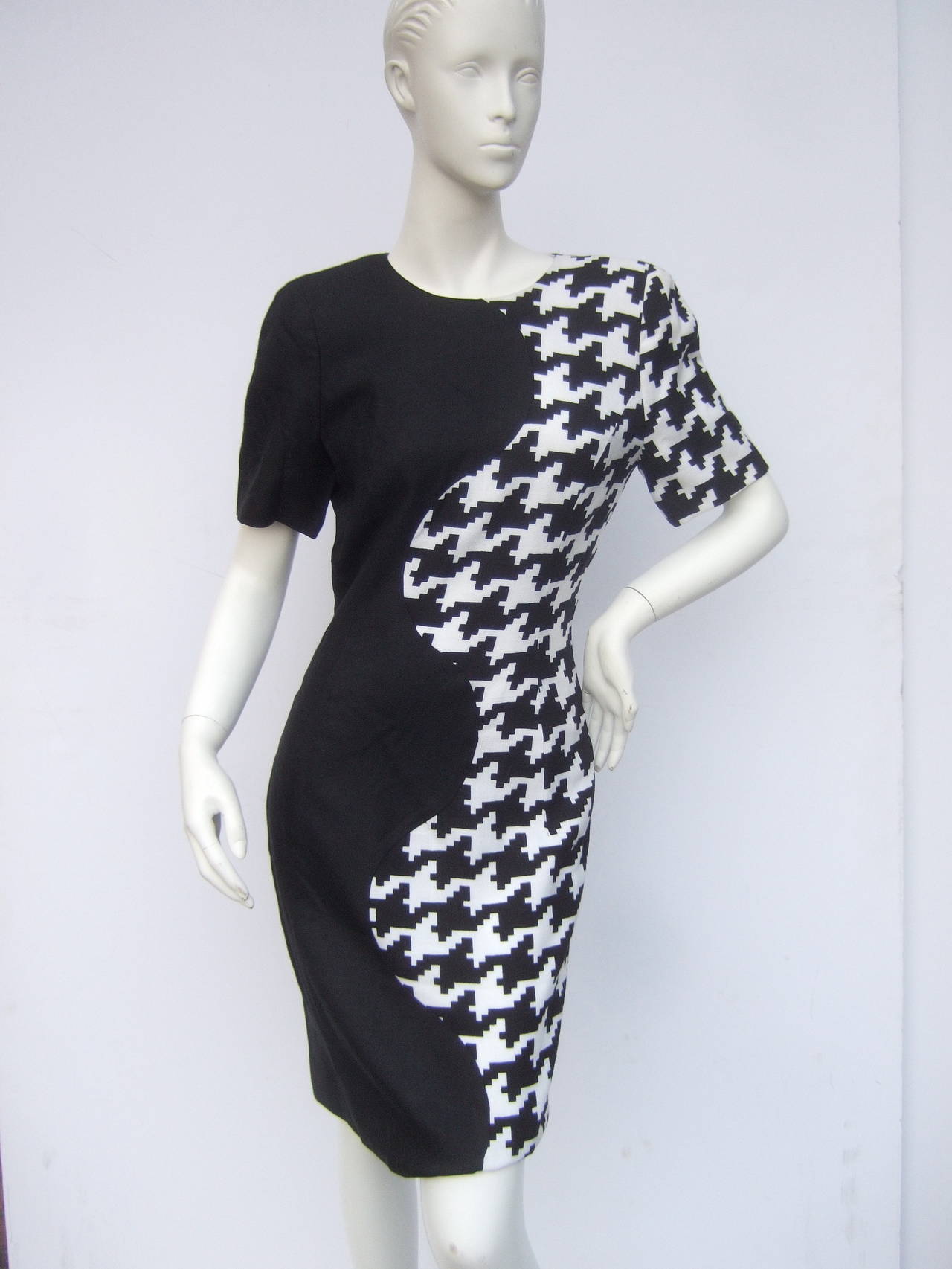 Carolina Herrera Mod color block linen blend sheath dress US Size 6 c 1990
The stylish dress is designed with a bold hounds tooth pattern 
combined with a solid black panel. The center of the dress has
a sinuous curved seam that runs down the
