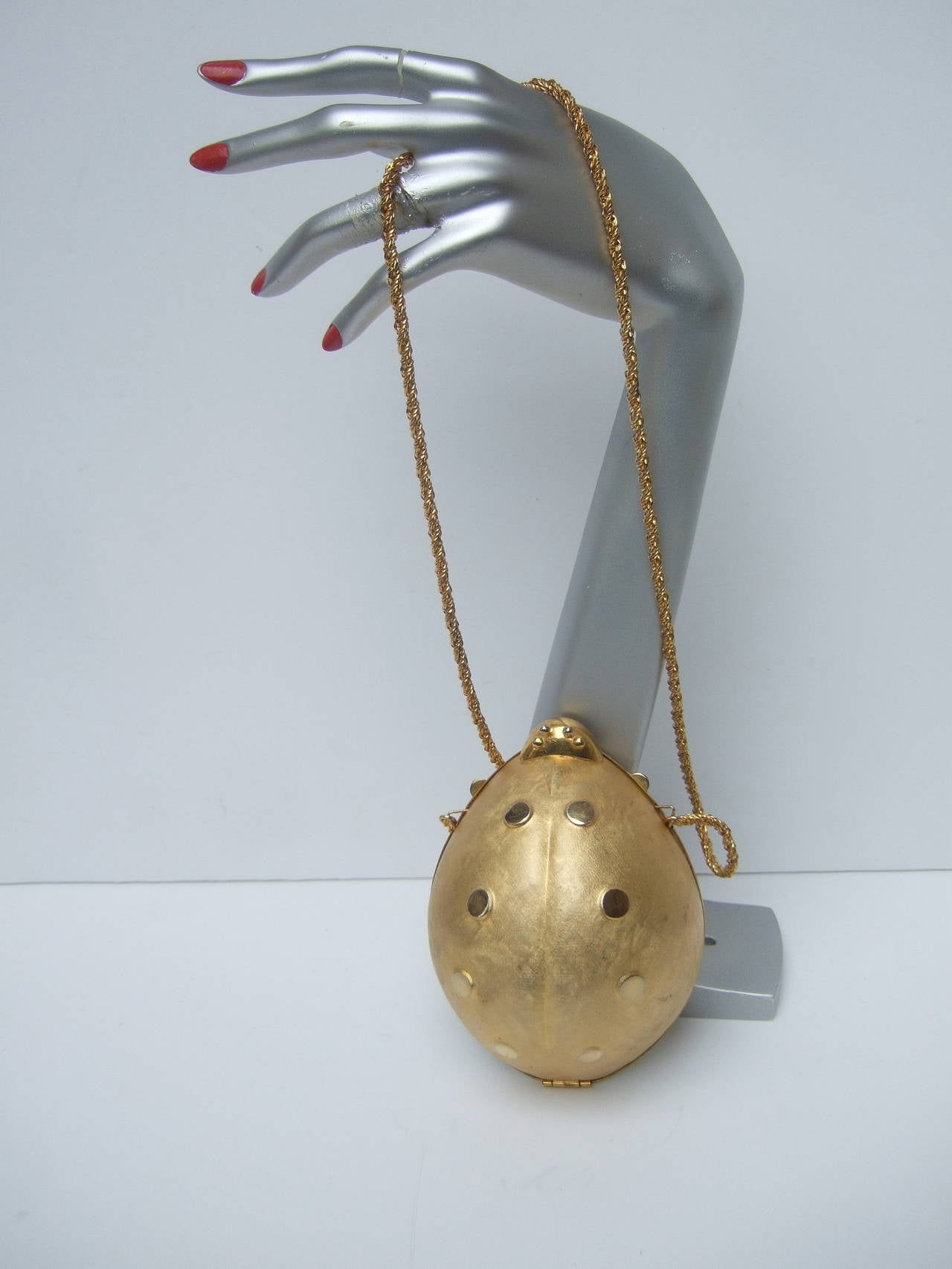 Opulent gilt metal lady bug evening bag Made in Italy c 1970
The unique gilt metal purse is designed in the shape 
of a charming lady bug. The exterior covering has 
a satiny brushed finish juxtaposed with smooth shiny 
circular dots. The lady
