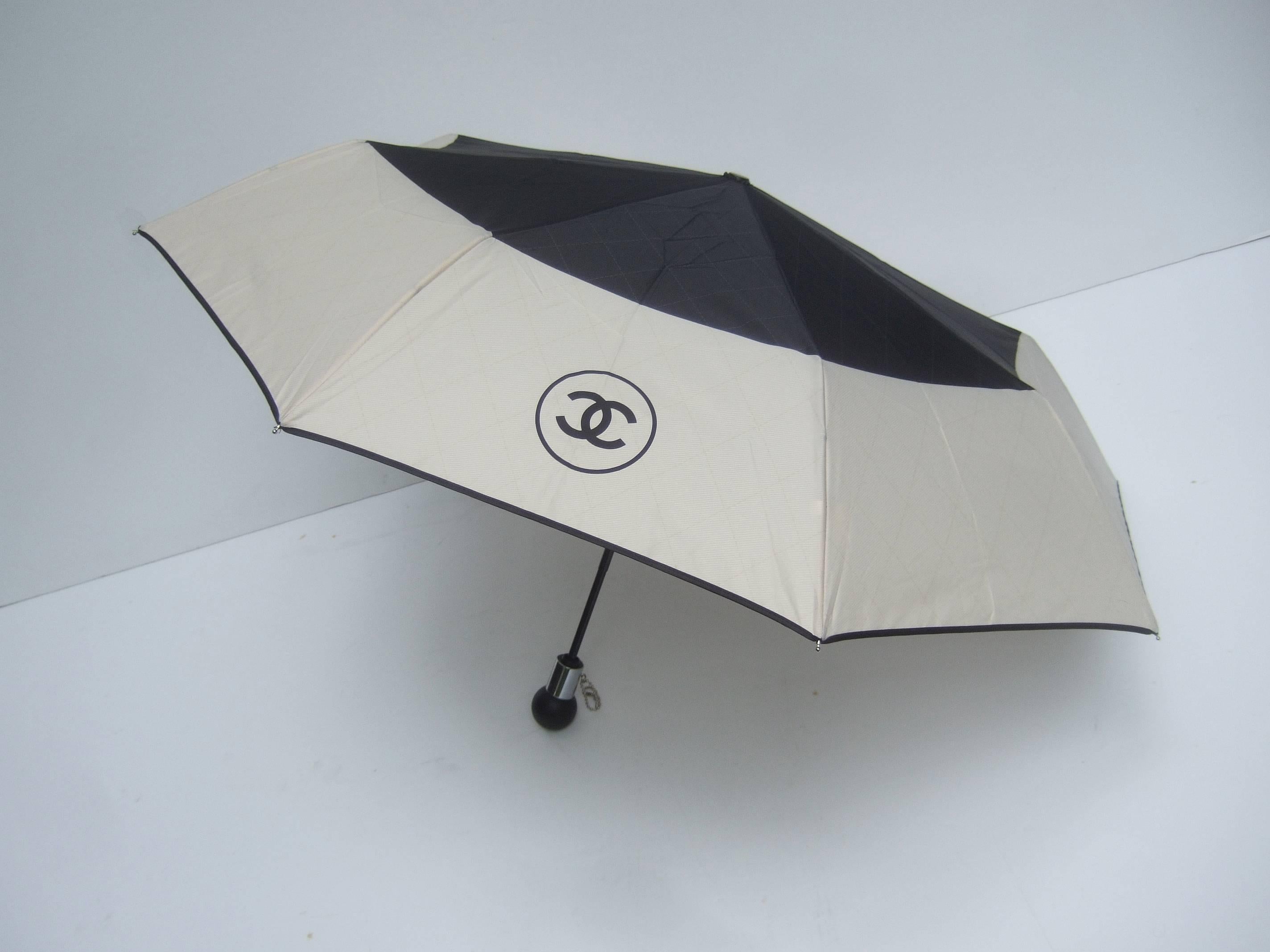 Chanel Stylish black and ivory nylon umbrella in Chanel Box
The chic umbrella comes with a quilted nylon cylinder carrying
case on a silver metal shoulder strap chain

The umbrella can be carried in the black quilted carrying case
The quilted