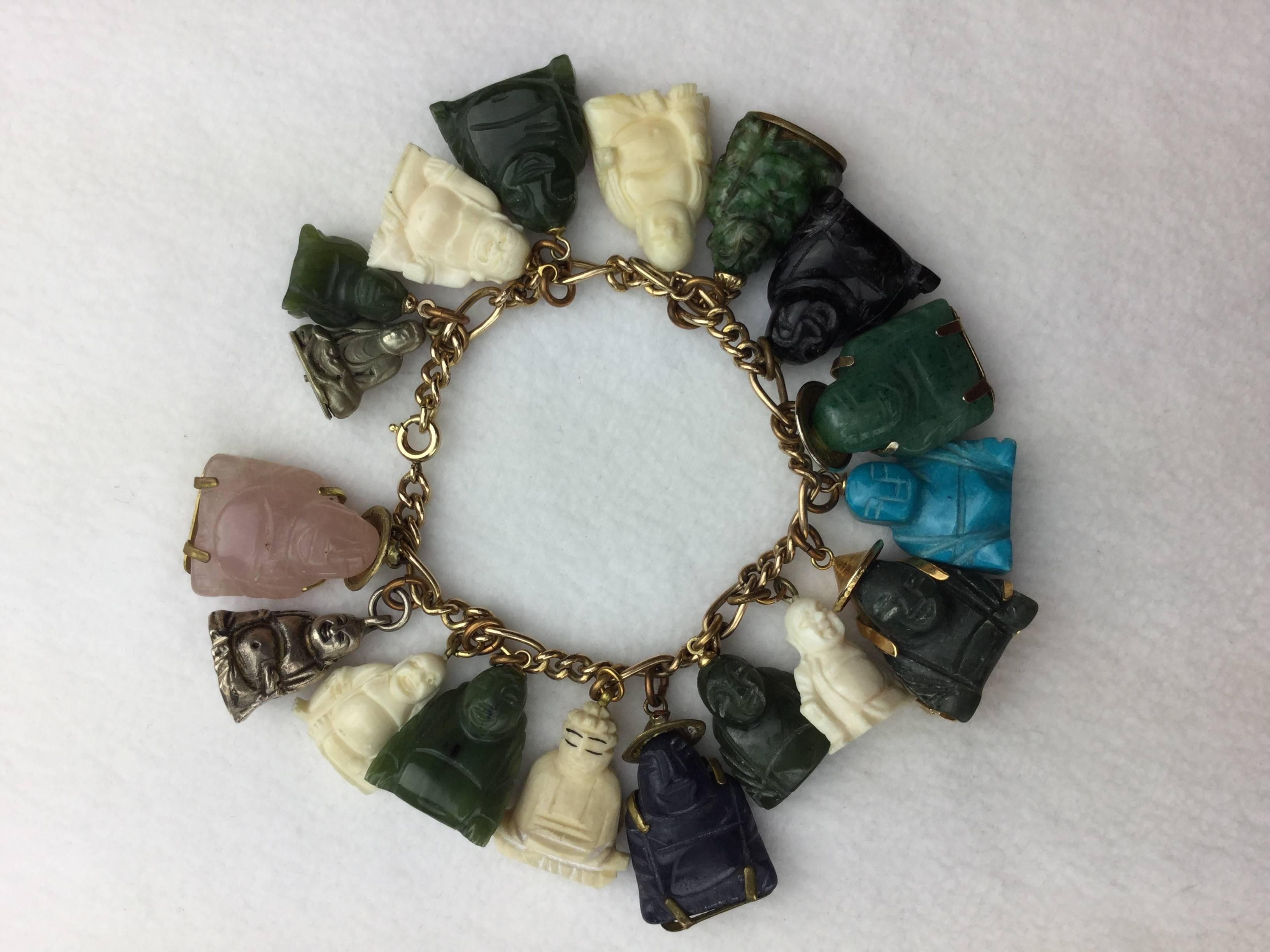 Interesting collection of vintage hand carved stone Buddha's on a gold filled charm bracelet.

This is clearly a collection that was acquired one-by-one, over time, as each Buddha charm is totally unique.

Variously carved jade, lapis, onyx,