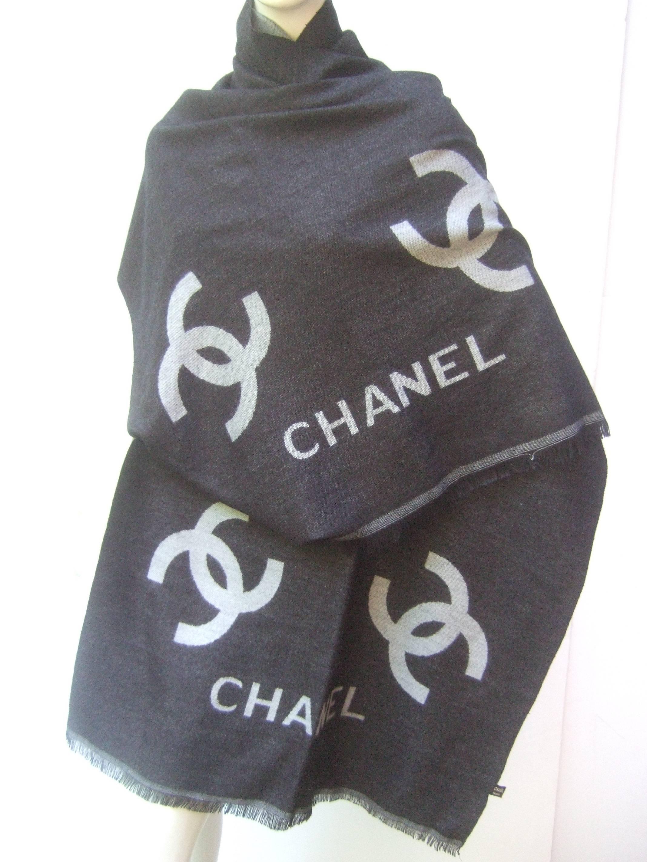 Chanel Charcoal gray silk wool blend shawl 
The stylish shawl is designed with a charcoal gray
background; contrasted with Chanel's C.C. iconic 
initials and the namesake Chanel name

The luxurious light weight silk and wool blend shawl
is
