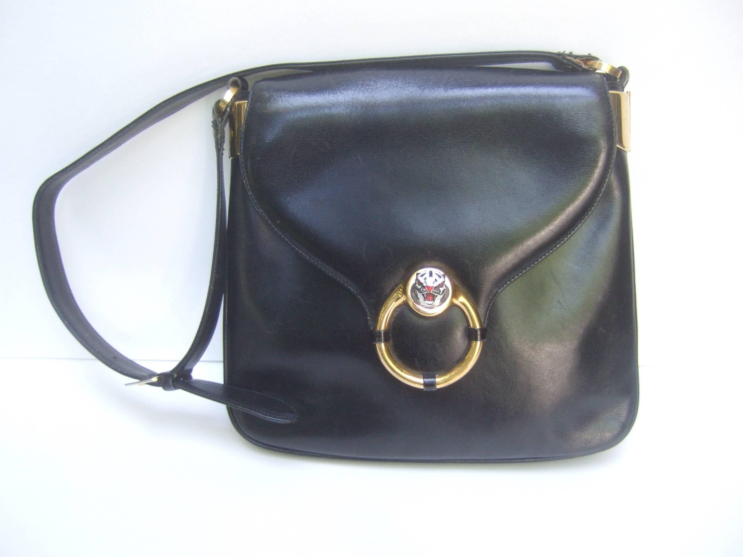 Gucci Rare ebony leather tiger emblem shoulder bag c 1970s
The Italian designer handbag is adorned with a
sleek gilt metal enamel tiger's head emblem

The handbag is covered with black leather
with a matching black leather adjustable 
shoulder