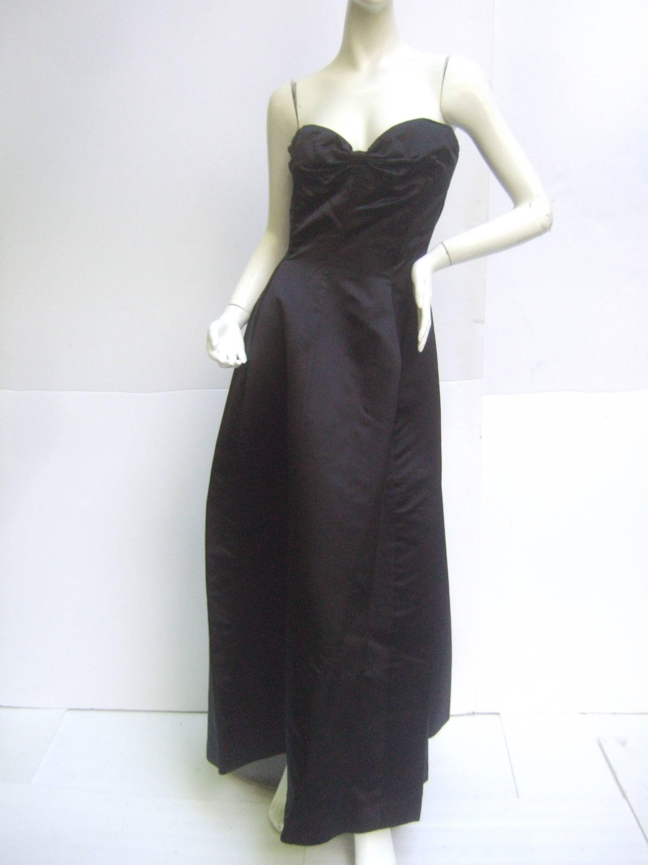 Christian Dior Demi-Couture strapless gown with fully  boned bodice made of heavy black silk. Gorgeous bow back. So simple and elegant! 
Measurements:  Bust: 33.5"   Waist: 27" Length: 51"
Condition is excellent aside from 2 tiny