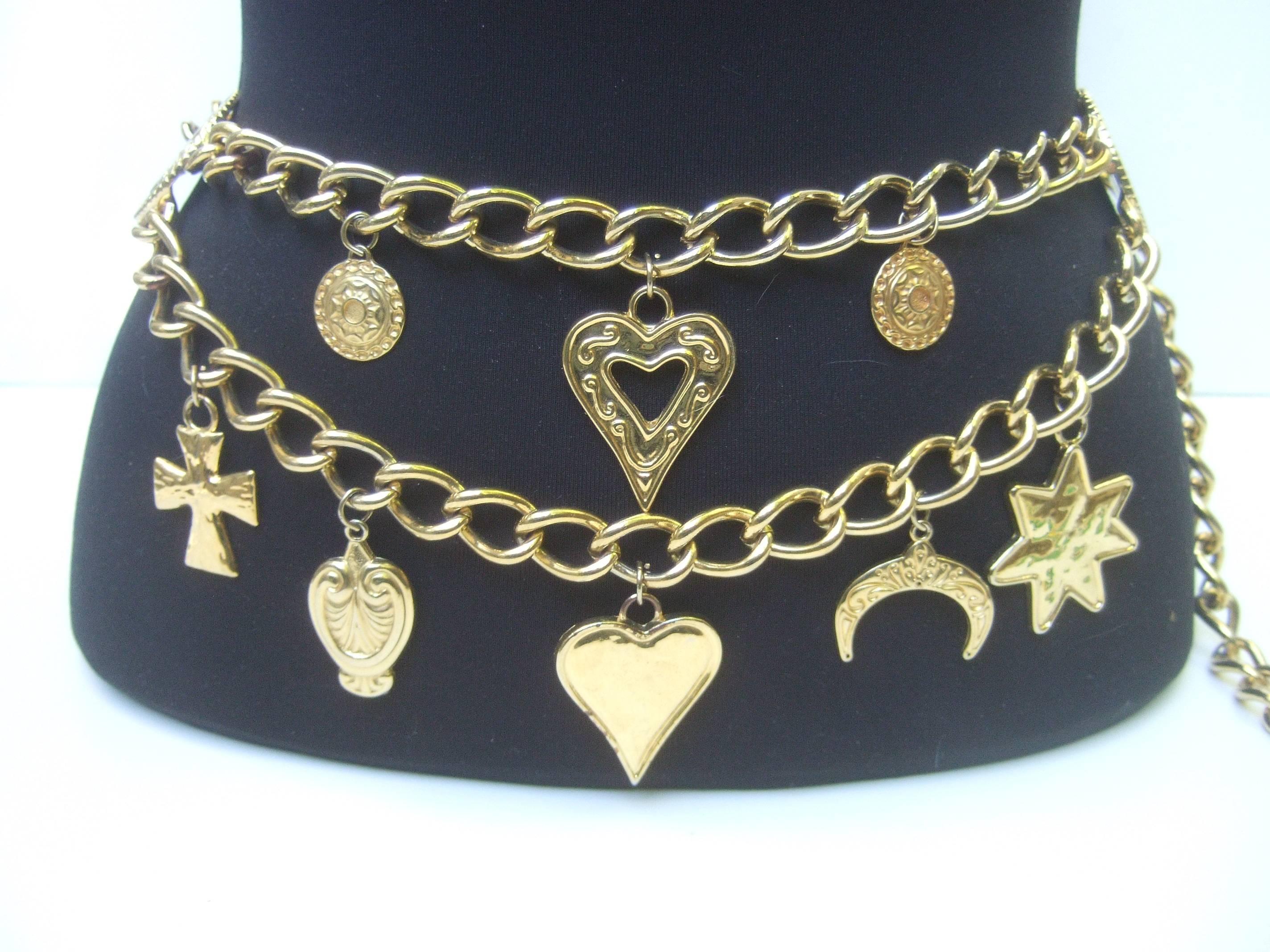 Ornate gilt metal medallion charm belt c 1980s
The stylish heavy chain belt is adorned 
with a series of chunky large scale charms
dangling from two rows of chains

The collection of dangling charms range  
from gilt hearts, stars, crescent