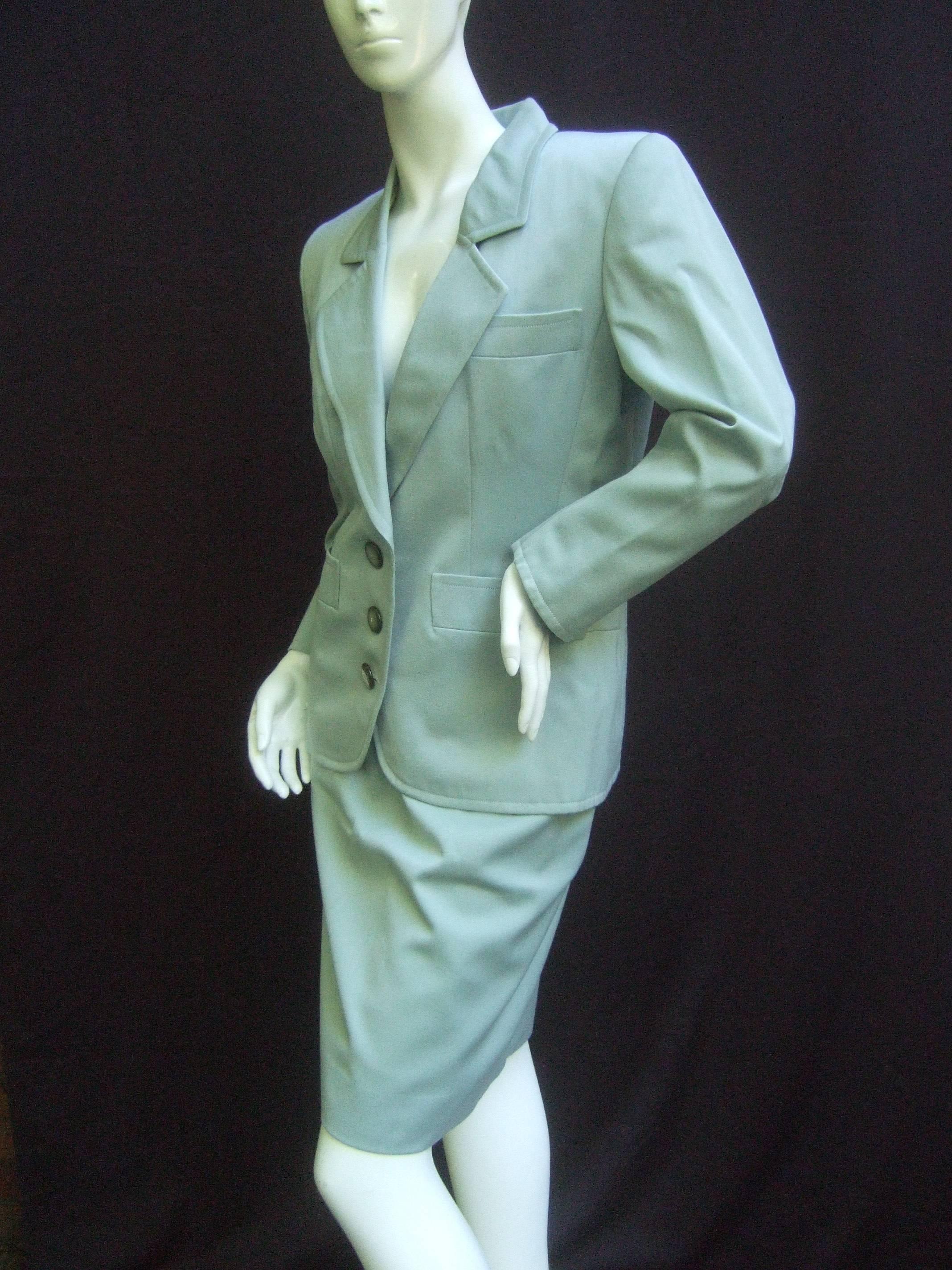 Beautifully tailored Yves Saint Laurent 1980's couture suit in sage green gabardine. Iconic 80's power dressing piece complete with shoulder pads.
Grey pearlised buttons. Silk lined. Sage green leather belt.  Leather belt loops. Skirt:Waist 26