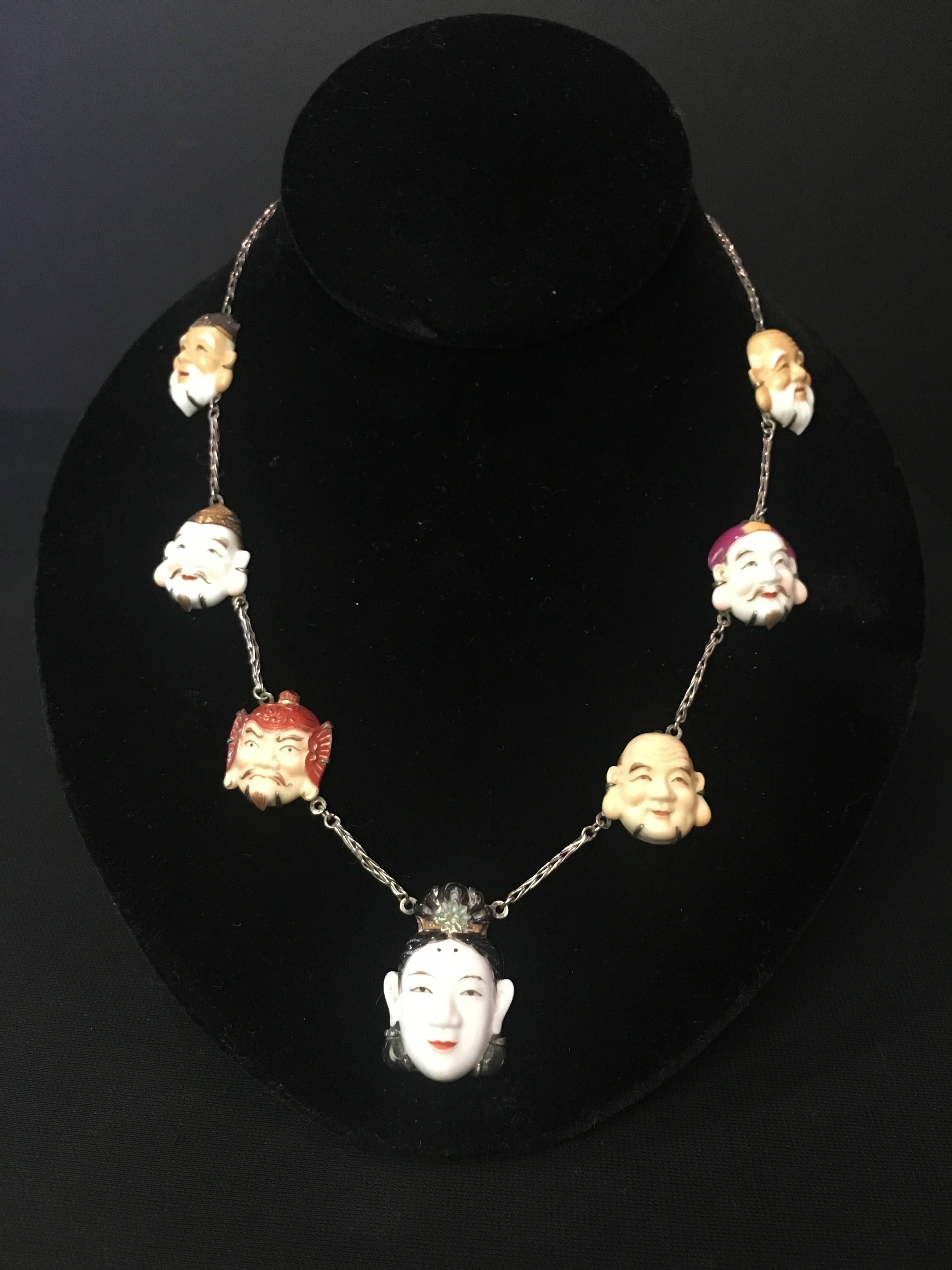 Spectacular  and extremely rare Toshikane Seven Lucky Gods necklace of porcelain faces set in silver. The detail on each Japanese deity is just incredible!  Excellent condition. The faces are divided by a braided silver chain which closes with a