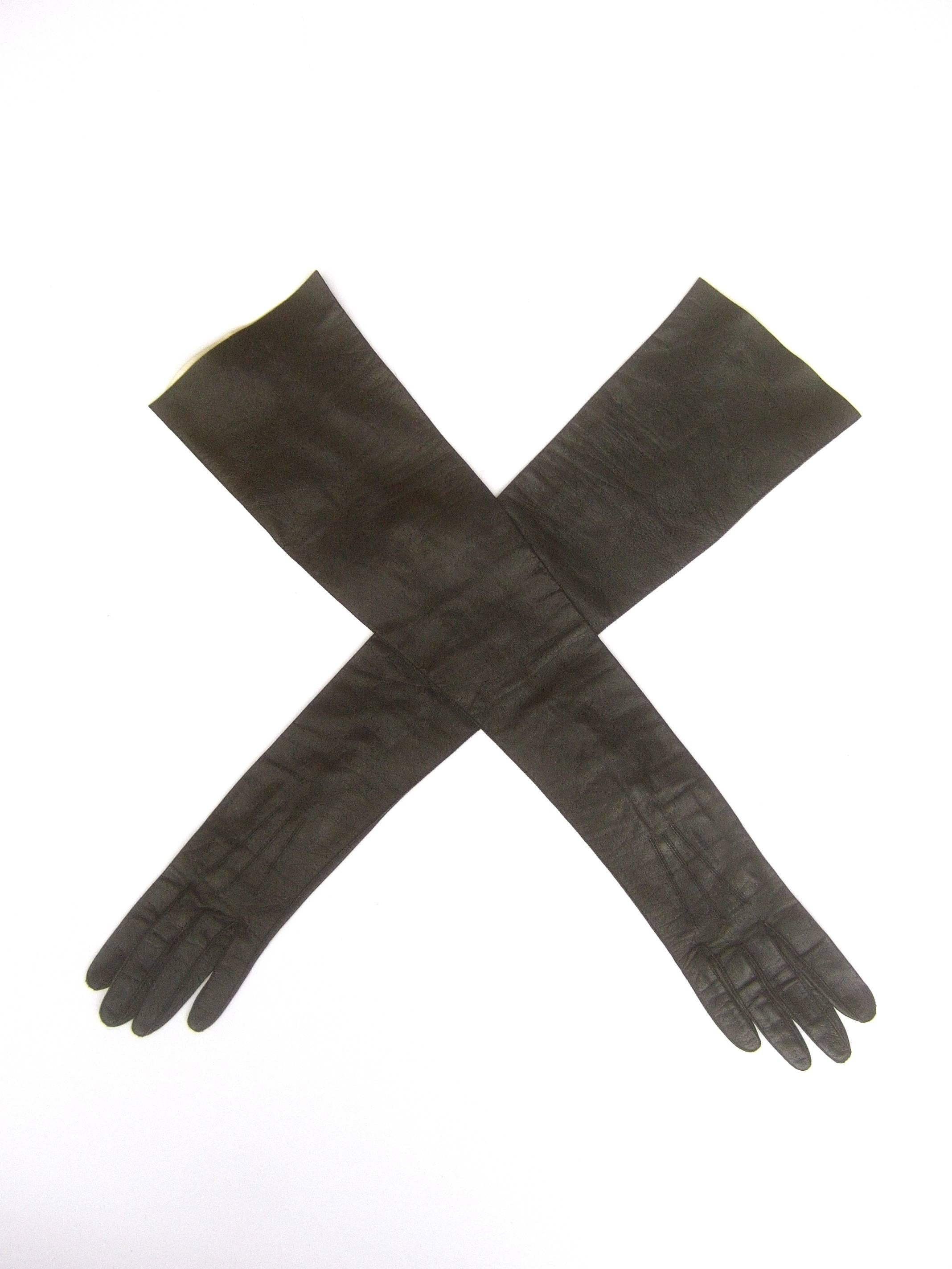 Sleek ebony opera length kid skin leather gloves
The stylish black leather long gloves make a very
chic dramatic accessory 

The length from the tip of the center finger 
to the opposite end at the opening measures 
23