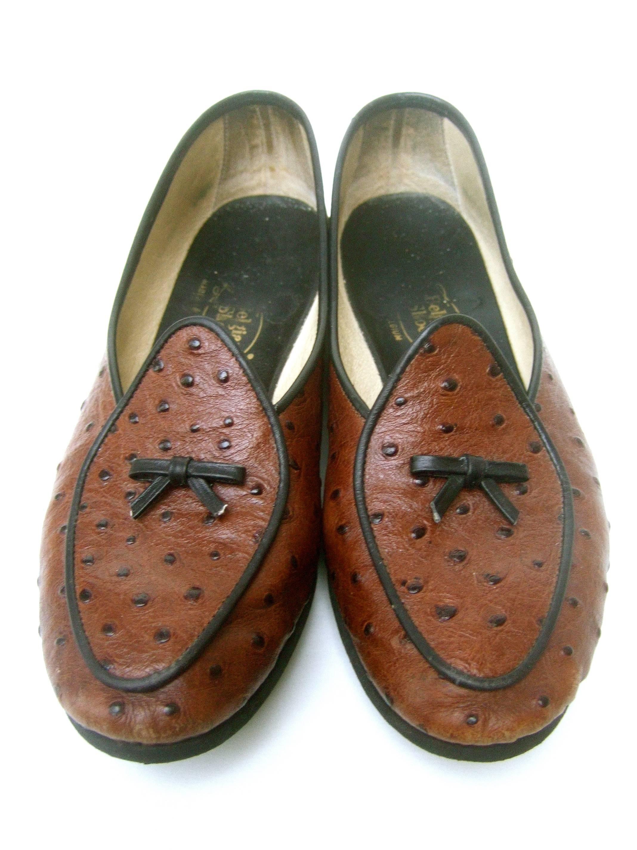 Belgian brown leather ostrich leather loafers US Size 7 WW 
The classic Belgian loafer flats are designed with 
brown ostrich leather; accented with their 
signature small bow detail on each shoe

The edges are framed with black leather
piping