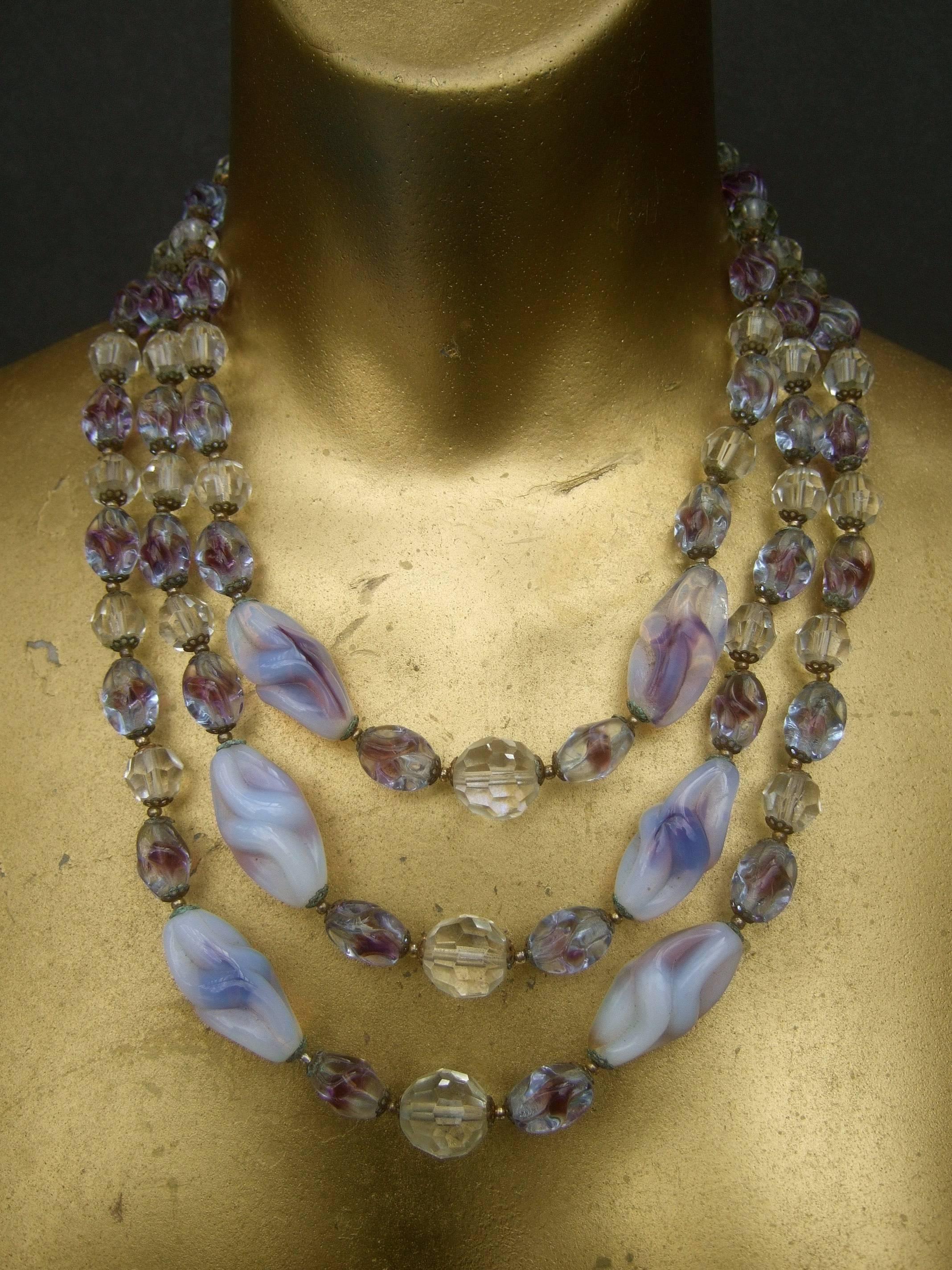 Glitzernde Kristallglasperlenkette, abgestuft, um 1960
Die elegante Halskette ist mit drei abgestuften  
reihen von blass lavendelfarbenen, milchigen, opalfarbenen, länglichen Glasperlen

Nebeneinander mit klarsichtigen Kristallperlen in