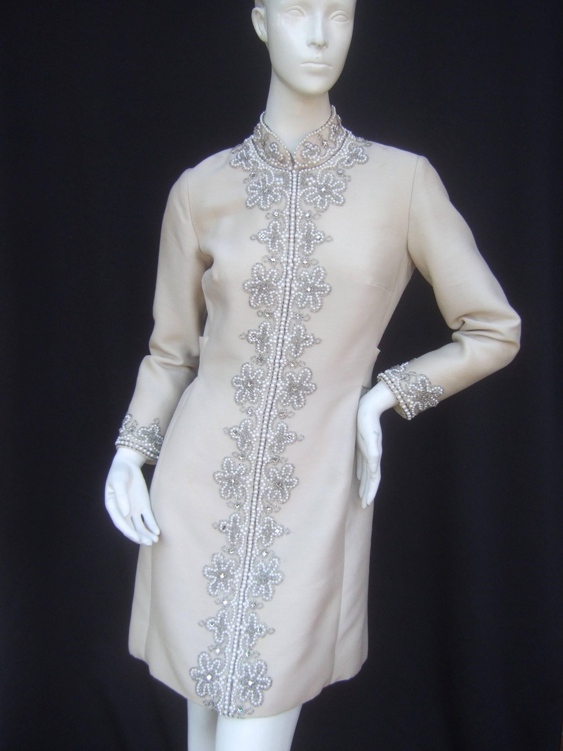 Neiman Marcus Champagne beaded tunic dress ca 1970
The elegant vintage douponi dress is embellished with 
elaborate glass beads, crystals, and enamel pearl beads

The exquisite beading frames the necklace, runs down 
the center and circles the