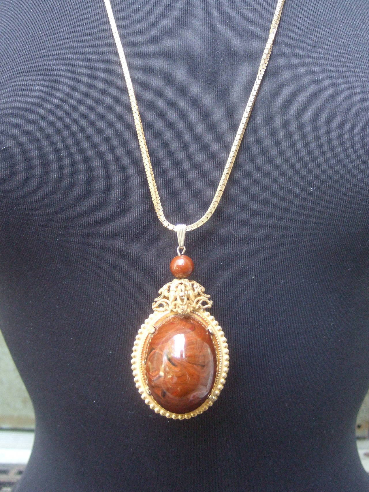 Miriam Haskell Brown lucite egg pendant necklace c 1970
The unique costume designer necklace is embellished 
with a large egg shaped pendant. The lucite pendant 
is designed with glossy brown hues with marbleized    
veining detail

The