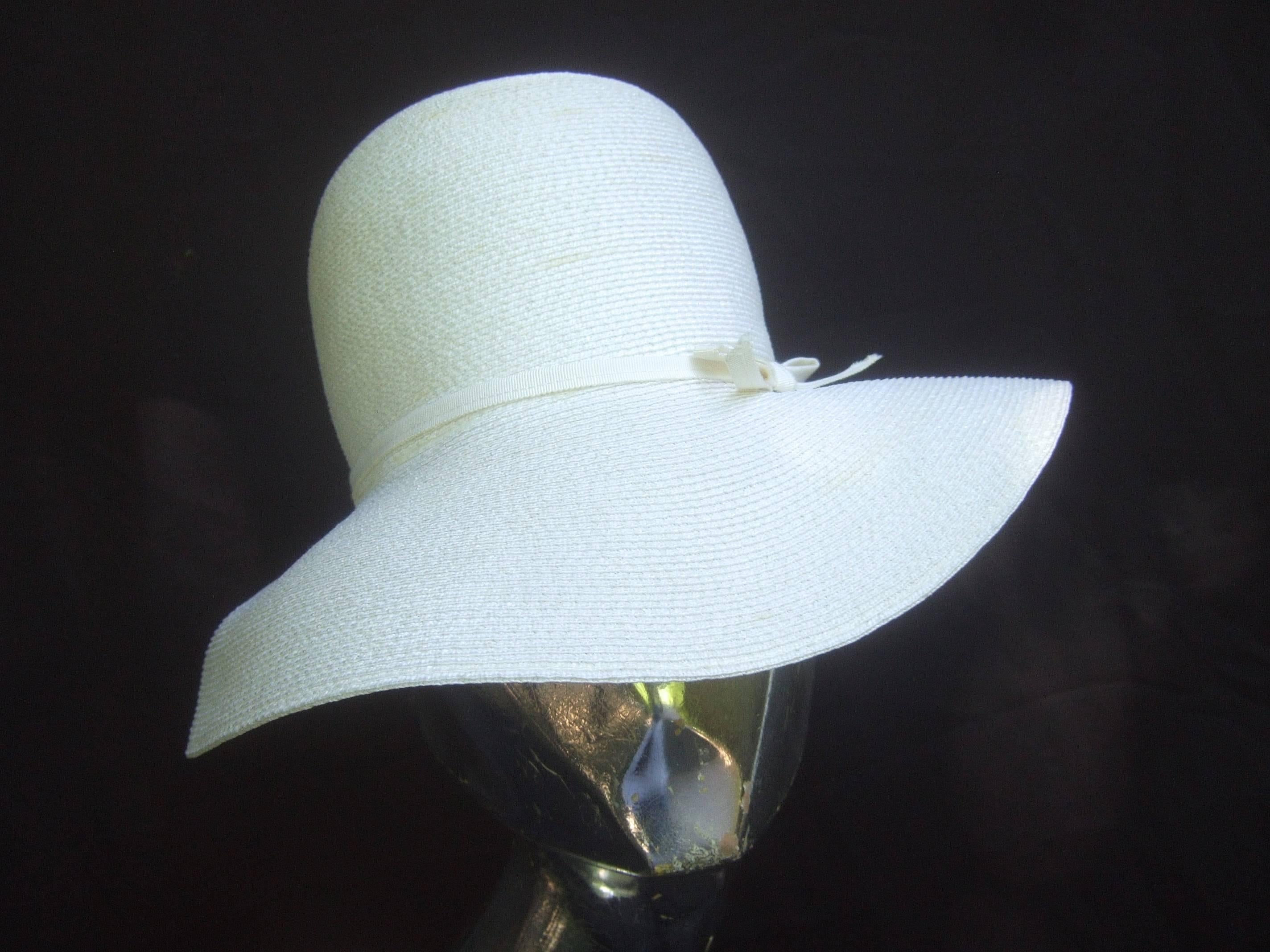 Saks Fifth Avenue Crisp white raffia summer hat c 1970
The stylish retro hat is designed with a delicate 
thin white grosgrain ribbon tied in a crisp bow 

Makes a very chic summer or resort wear accessory 
Perfect for weddings, garden parties