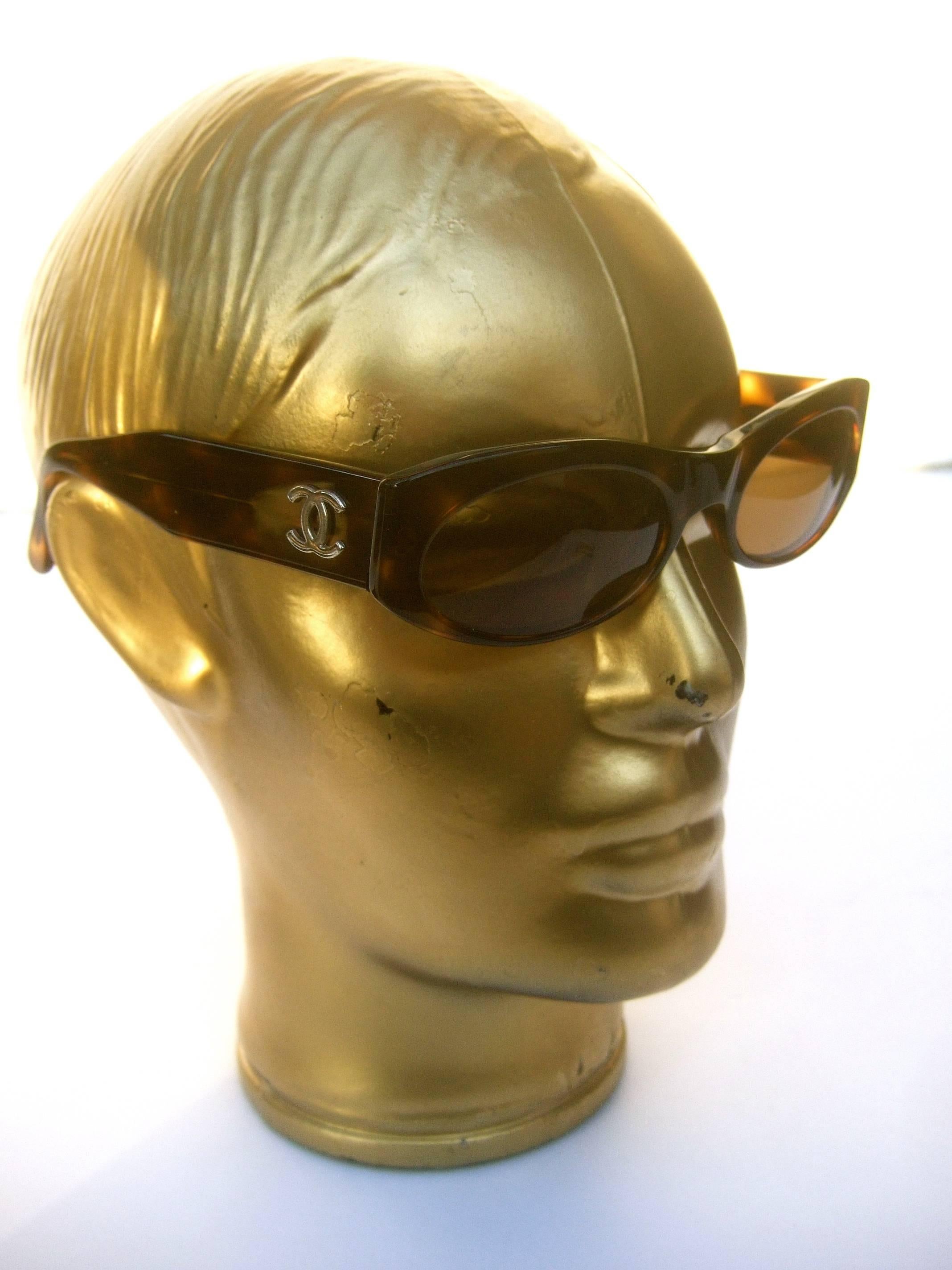 Chanel Italian tortoise shell lucite sunglasses in Chanel case 
The stylish sunglasses are adorned with with Chanel's 
iconic C.C. initials on the sides

The tinted lenses are light brown plastic. Paired with the
Chanel storage case 

Makes for a