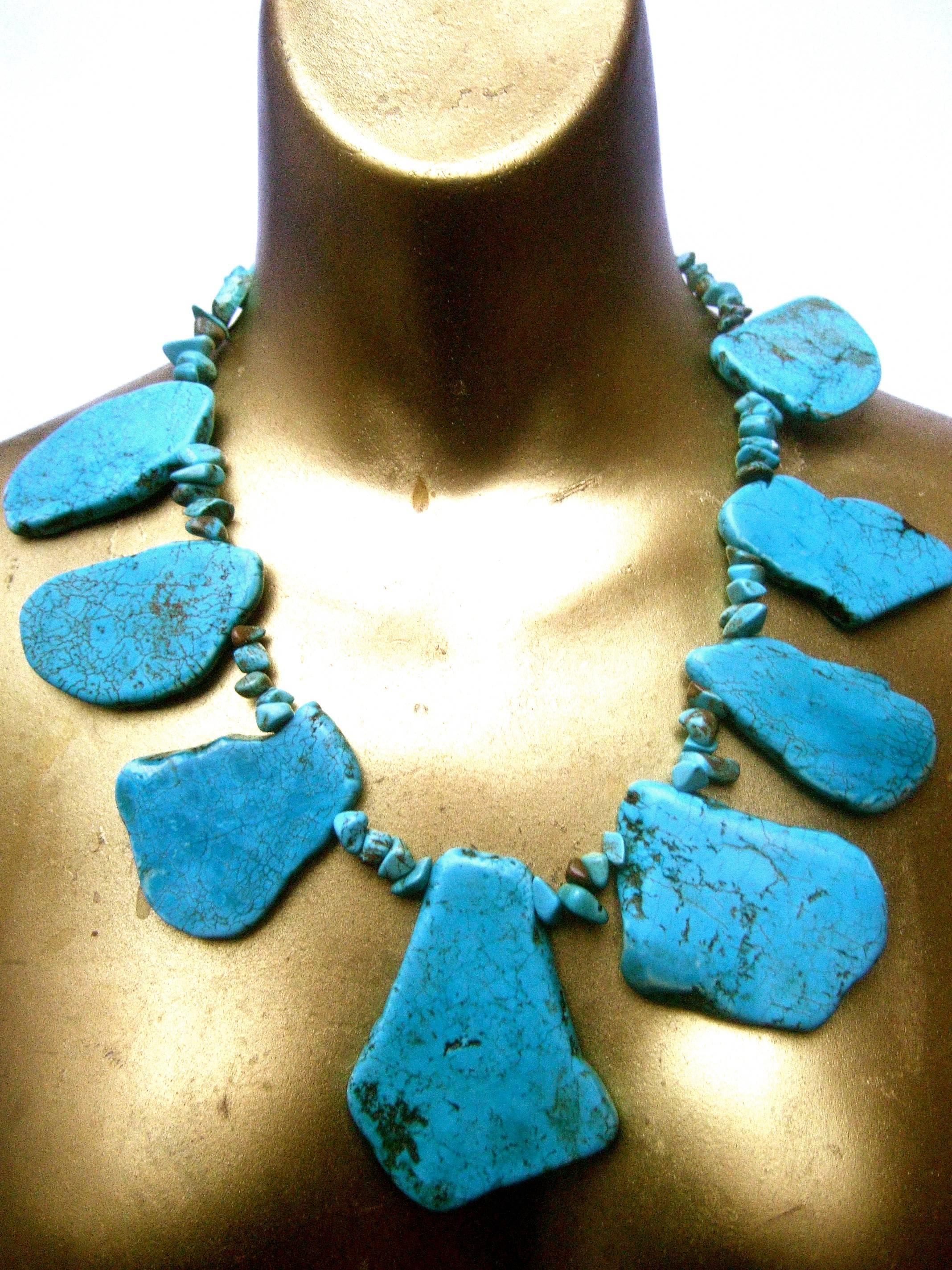 Artisan stone turquoise color howlite statement necklace c 1990s
The massive necklace is designed with a collection of organic
sliced smooth dyed turquoise color tiles

The large scale stones are suspended from a wire embellished
with small jagged