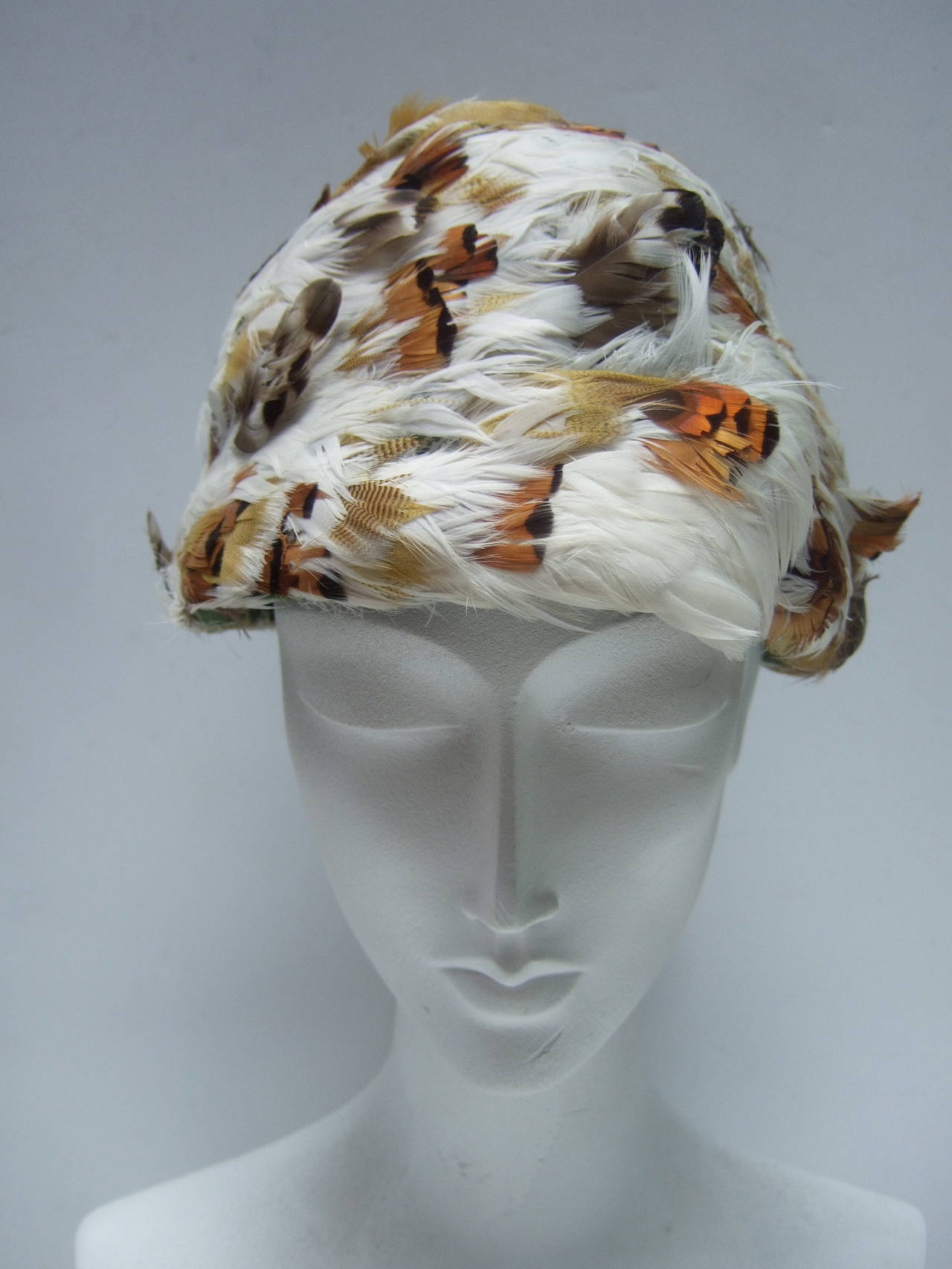 Schiaparelli Exotic feather dome hat Made in Italy c 1950
The chic retro is hat embellished with a myriad of white,
golden yellow & brown feathers 

Labeled Schiaparelli Paris Made in Italy 

The interior base of the hat is moss green 
felt