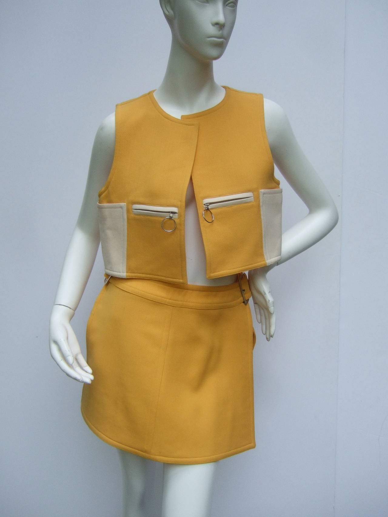 Courreges Paris Mod Wool Vest & Skirt Ensemble c 1970
The chic retro set is designed with a cropped wool vest
with zipper ring pockets. The back exterior side of the vest
is accented with an ivory wool panel. The unique panel design 
has