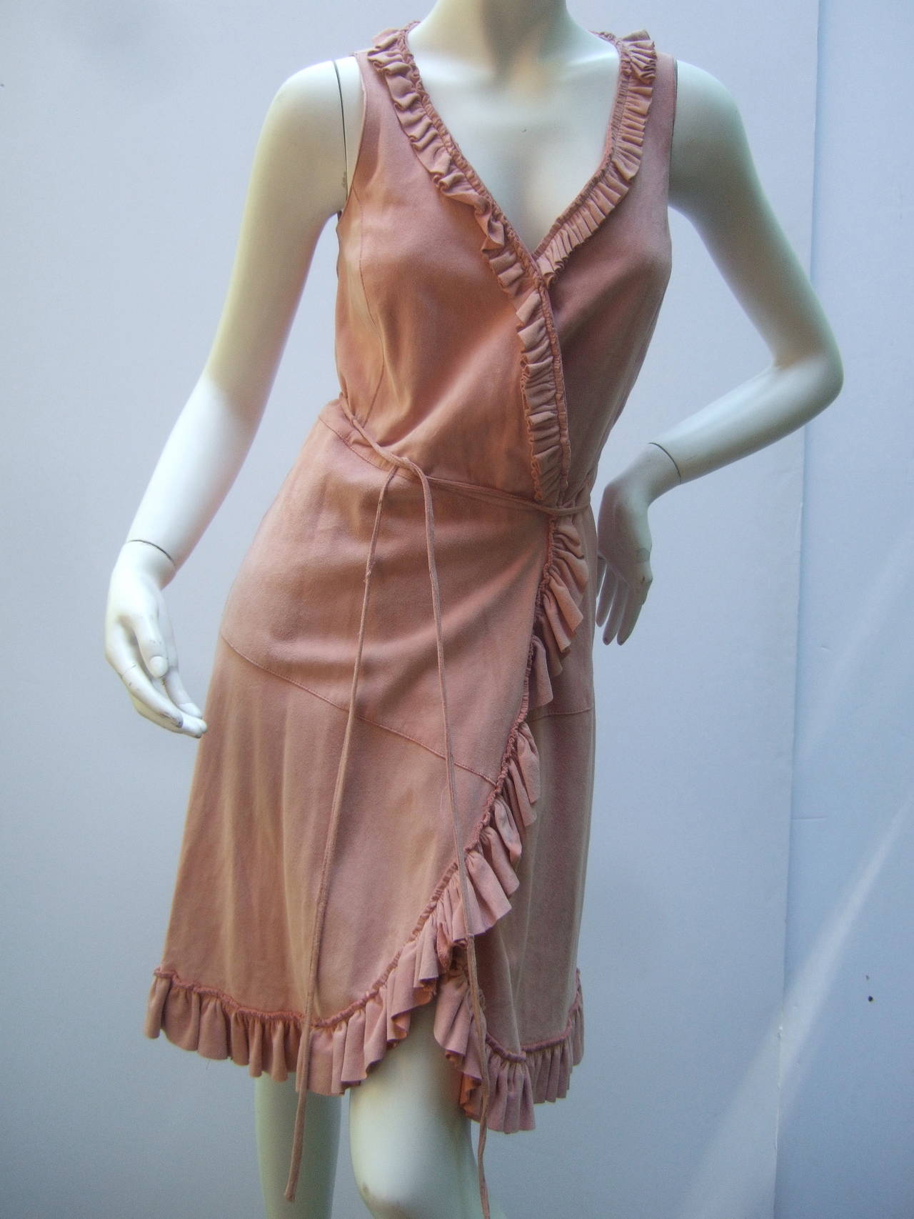 Stylish blush pale pink doeskin suede wrap dress US Size 6
The chic dress is designed with luxurious soft suede
The dress is accented with ruched suede ruffles that 
frame the collar, run down the center & circle the hemline

The dress is