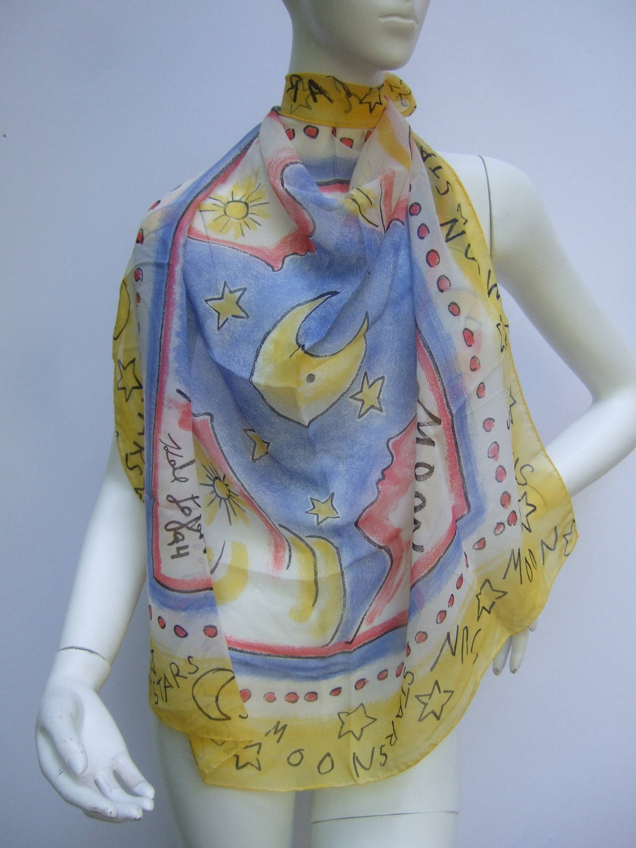 Karl Lagerfeld Silk celestial sun, moon & stars scarf c 1994
The stylish sheer scarf is illustrated with four ethereal women
in each corner. The center graphics are illuminated with a midnight
blue sky embellished with a crescent moon & clusters