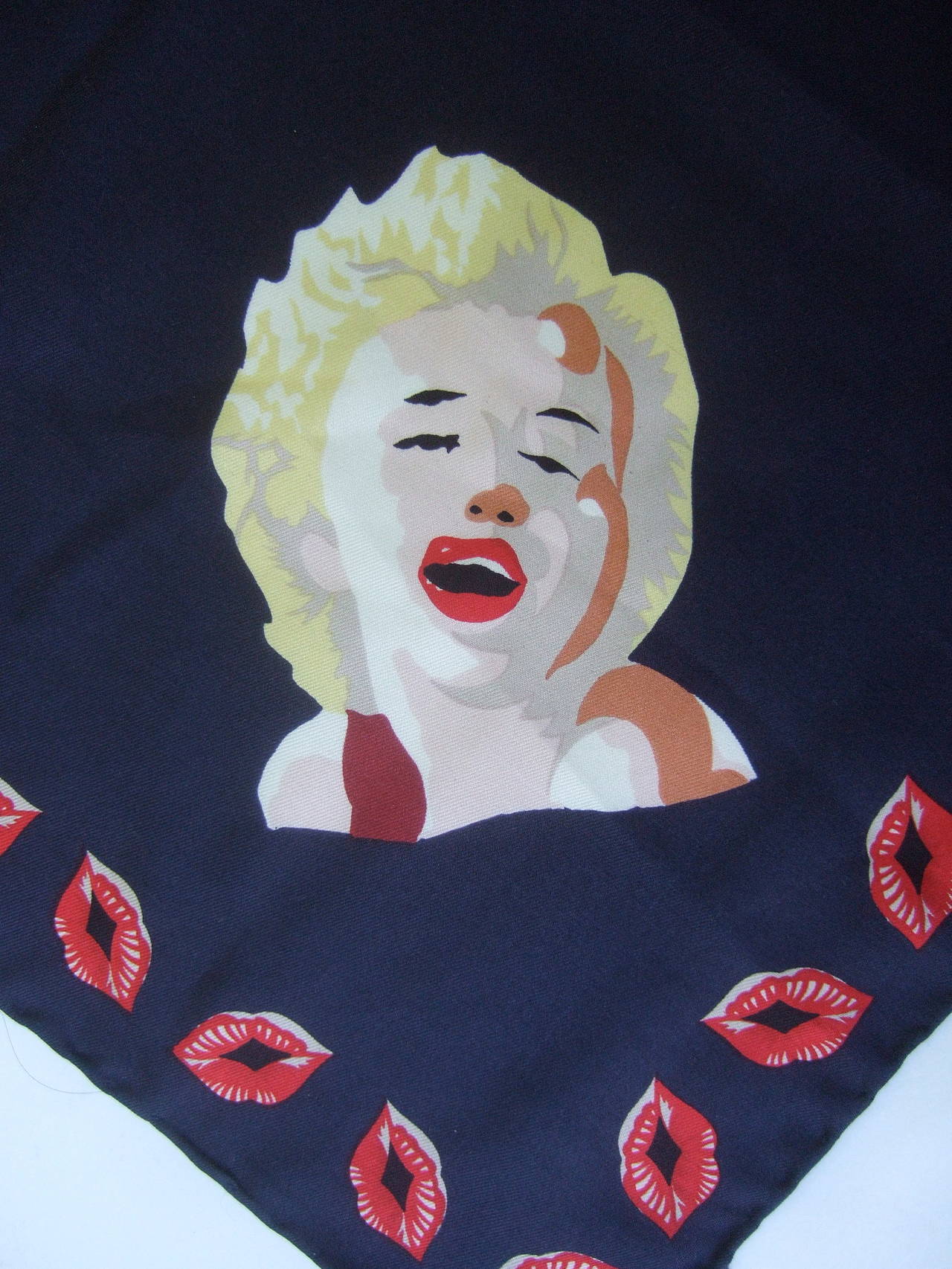 Marilyn Monroe inspired silk pocket scarf Made in Italy c 1990s
The unique hand rolled silk scarf is illustrated with four
silk screen images with the likeness of Marilyn Monroe 

The dark blue silk background is framed with puckered 
red lids