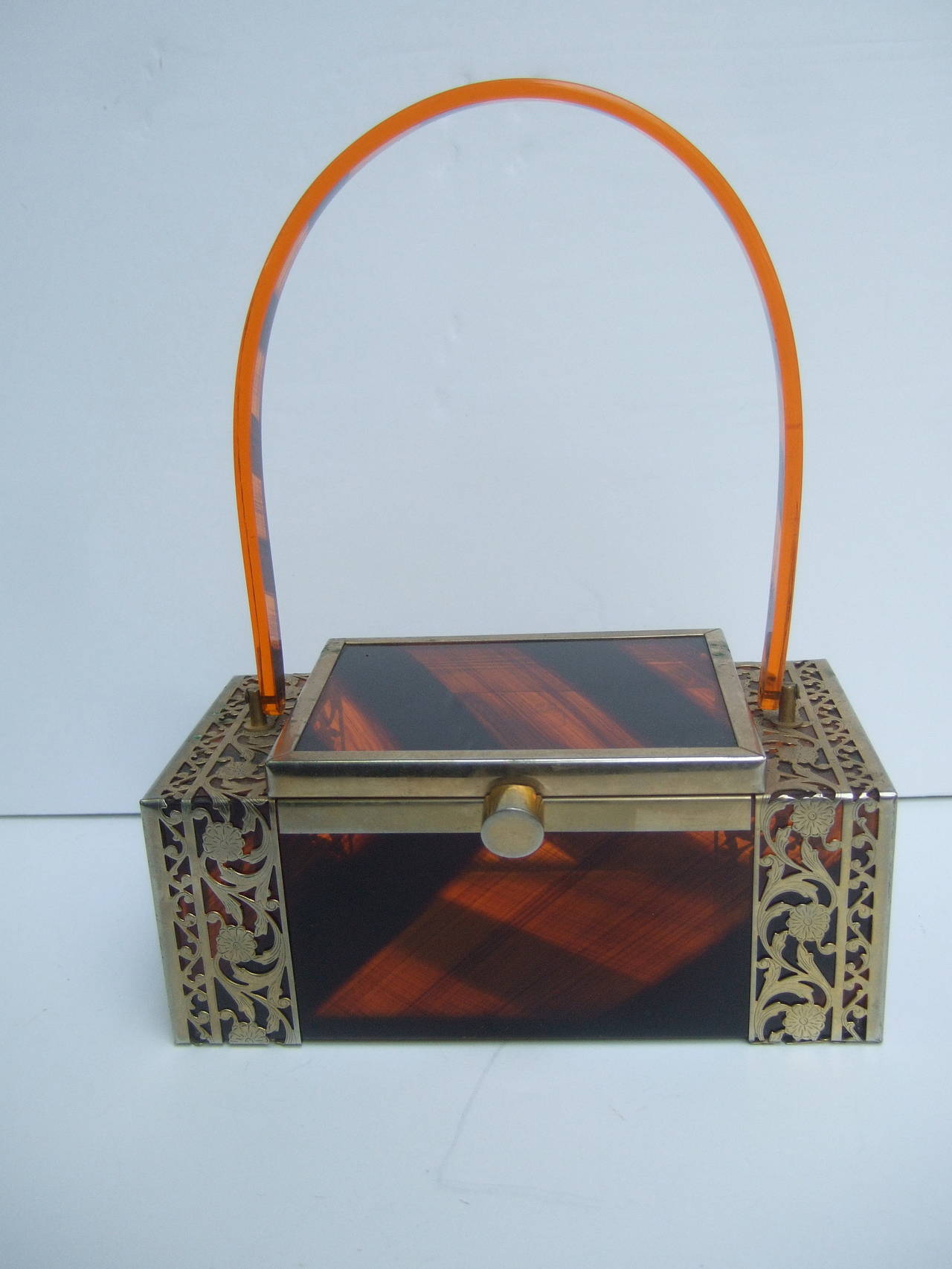 1950s Tortoise shell lucite filigree box style handbag 
The sleek retro handbag is constructed with brown
& amber color streaked lucite panels 

The mid-century box shaped handbag is framed
with gilt metal filigree borders. The swivel
