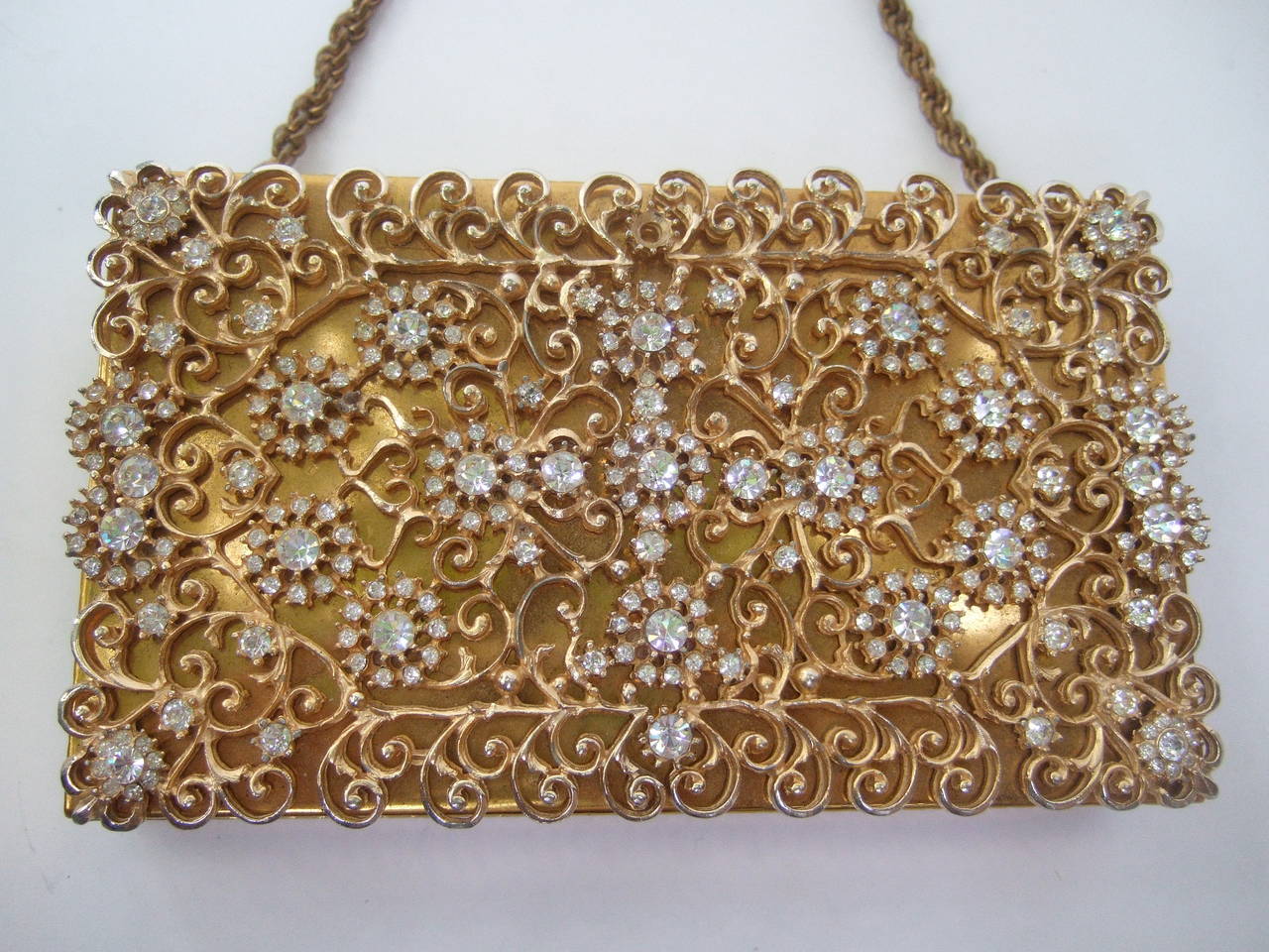 Opulent crystal gilt metal evening bag case designed by Evans c 1960
The elegant gilt metal case is encrusted with glittering diamante 
crystals on the front panel. The crystals are designed in circular
clusters emulating flower pedals 

The