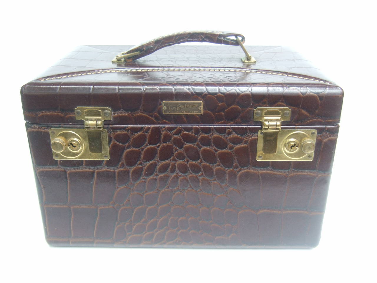 Saks Fifth Avenue Embossed brown leather travel case c 1960
The elegant retro travel case is covered with mahogany 
embossed brown leather that emulates alligator skin

The vanity style travel case has brass metal latch clasp
mechanisms & is