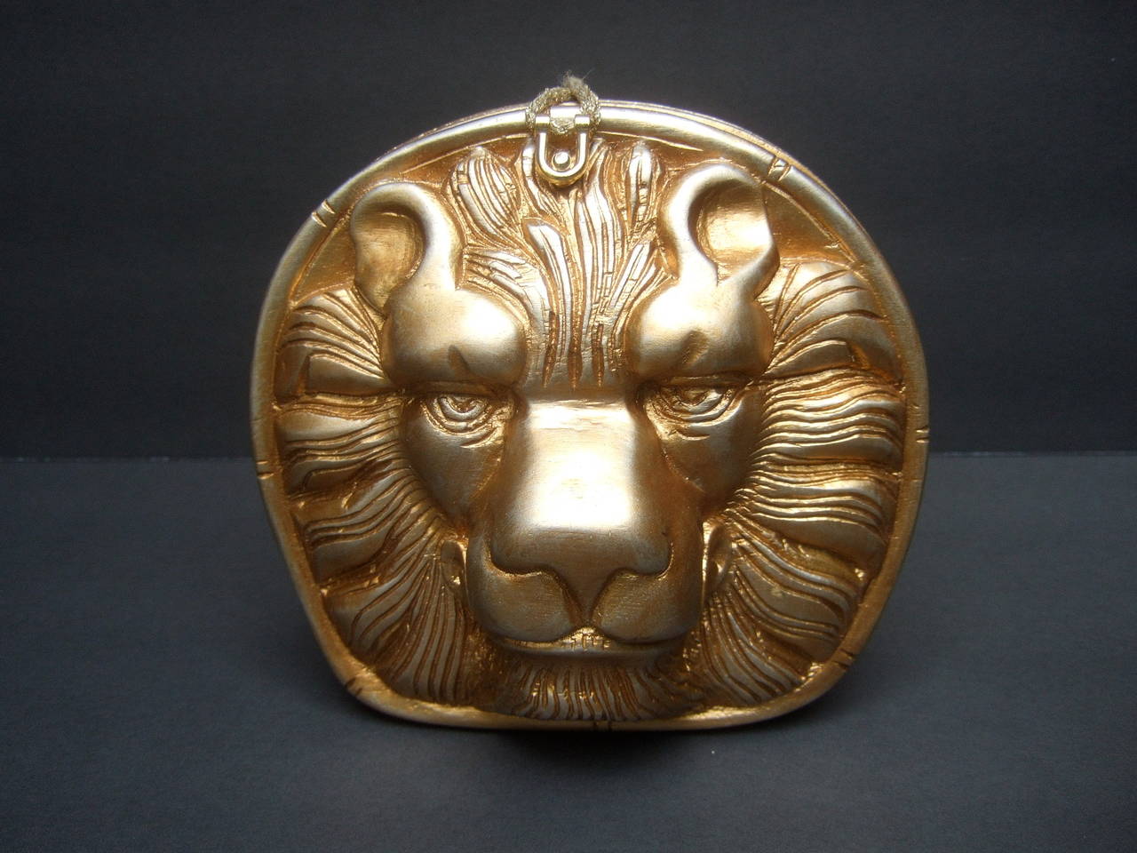 Artisan gilt enamel lion handbag designed by Timmy Woods Beverly Hills
The wood hand carved lion head handbag is covered with gold enamel
The versatile design transitions from a chic clutch bag into a stylish
shoulder bag carried with the bronze