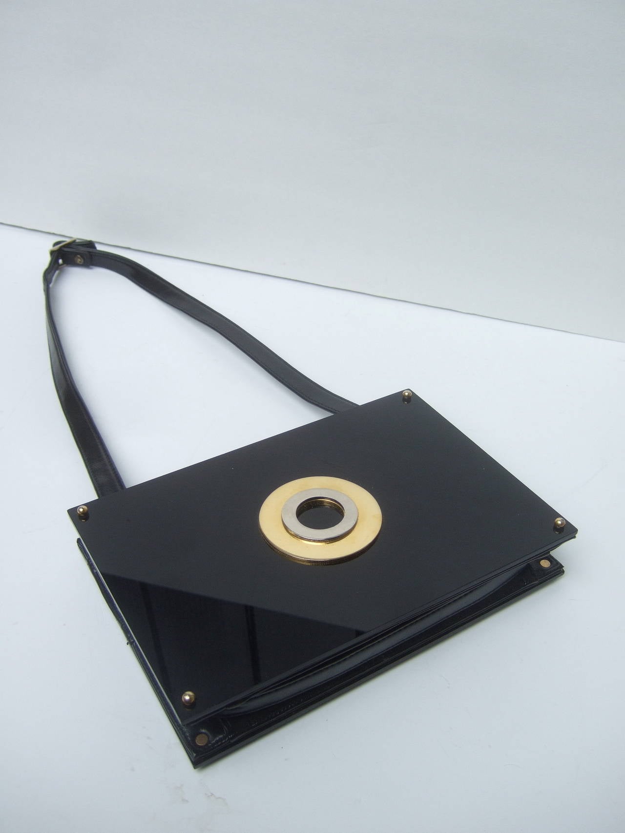 Sleek black lucite clutch style shoulder bag c 1970
The mod retro handbag is designed with two rectangular
black lucite panels on the front & back exterior

The versatile design can be carried as a chic clutch 
bag by removing the black vinyl