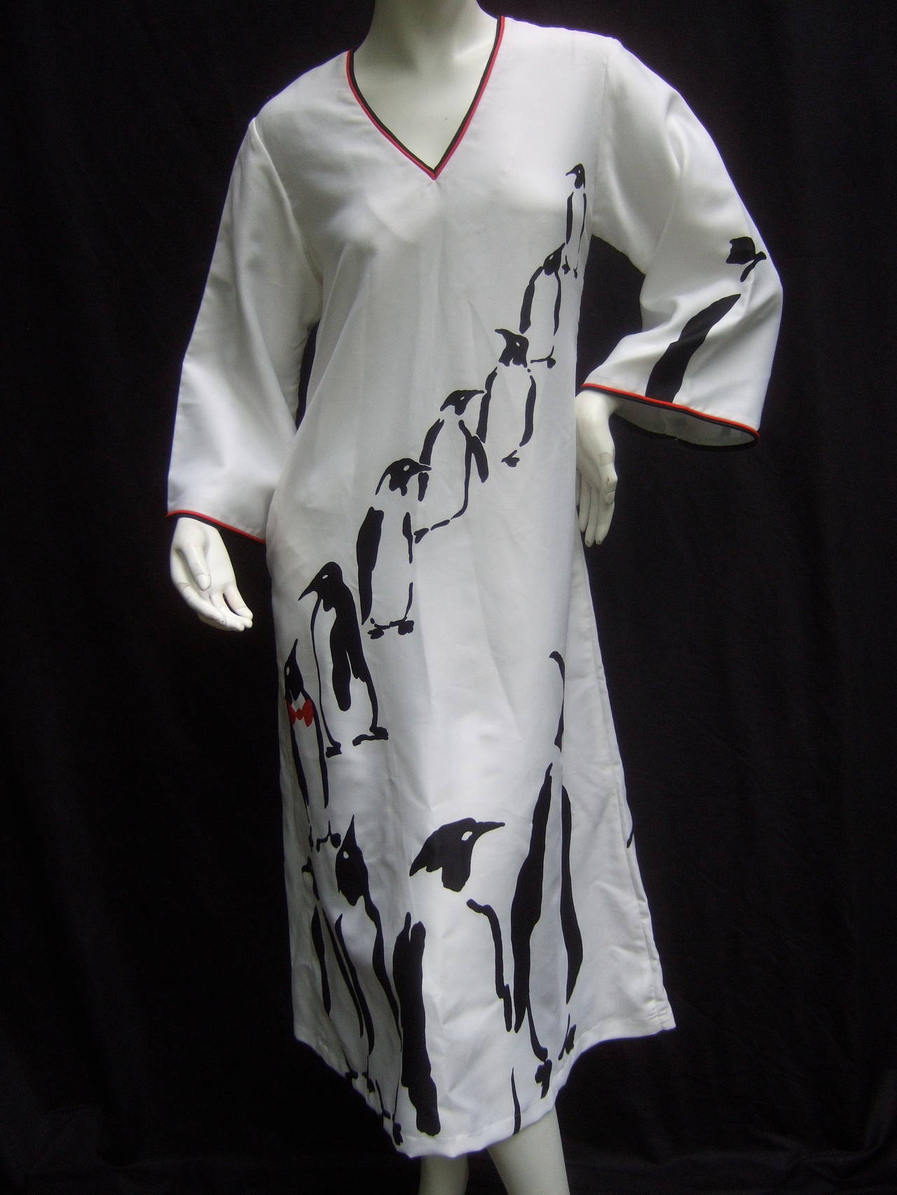 Avant-garde bold graphic print penguin dress / gown c 1970s
The unique design is illustrated with a series of penguin
figures. The black silhouettes of the penguins are illuminated
against the stark white background. Two of the penguins 
are