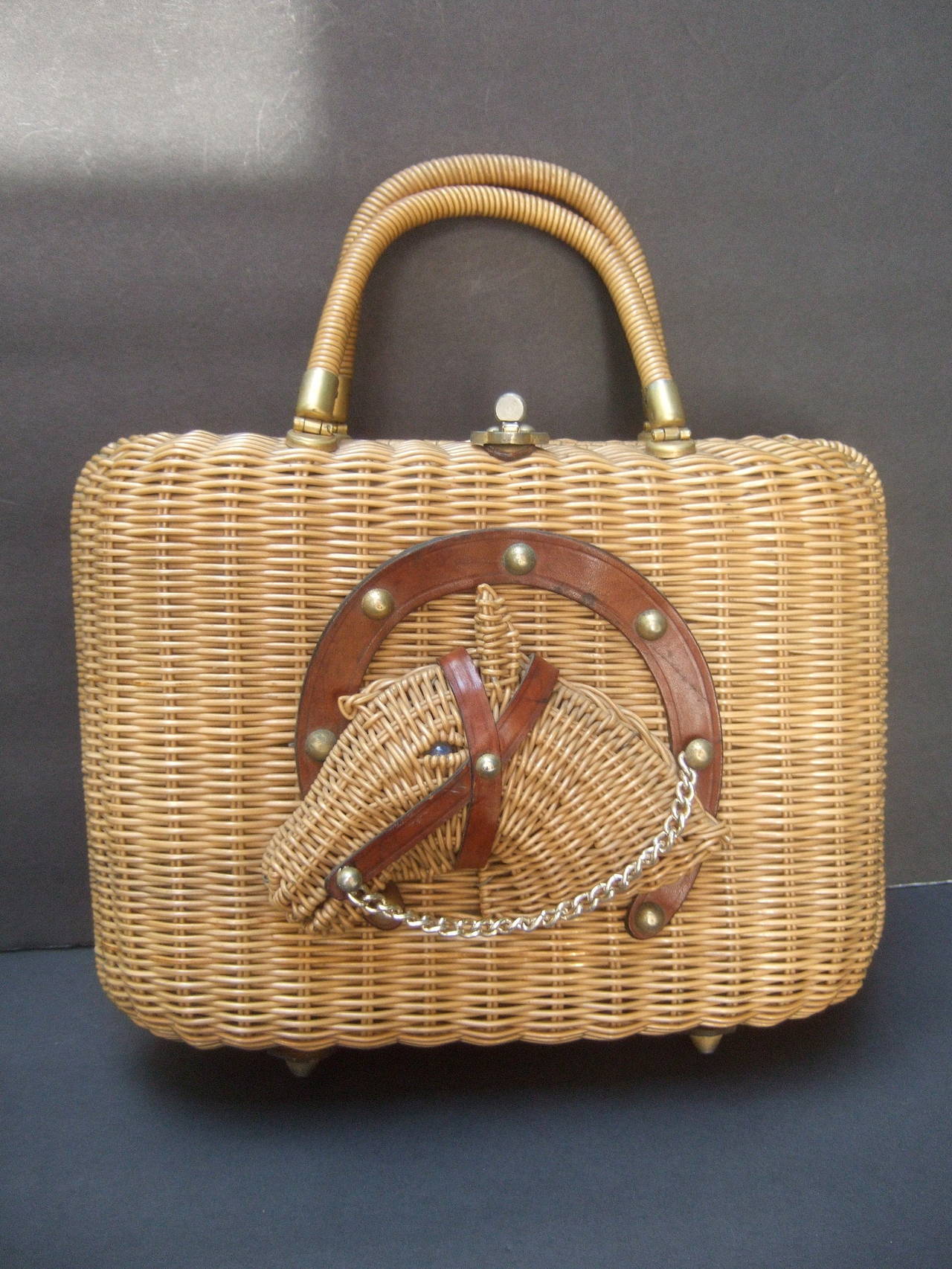 Unique wicker horse head retro handbag c 1960
The vintage wicker handbag is designed with a three
dimensional horse head; framed with a brown leather
horse shoe, leather bridals & a gilt metal chain 

The stylish retro handbag is carried with