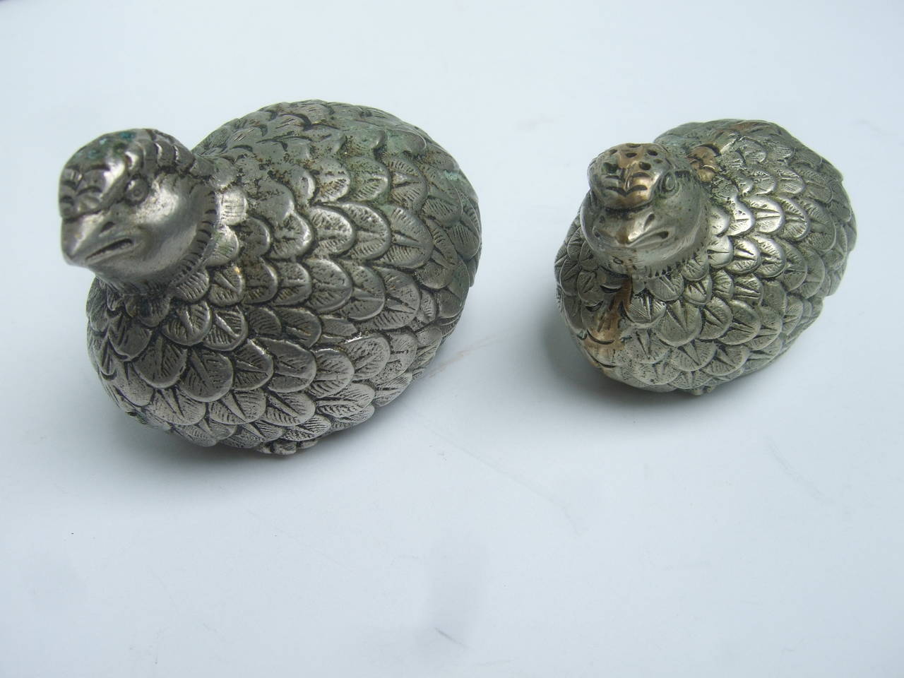 Gucci Italy silver metal quail salt & pepper shakers c 1970
The Italian figural bird spice shakers are designed 
with pewter tone silvery metal. The birds feather are
designed with an etched textured finish

The pair of salt & pepper shakers