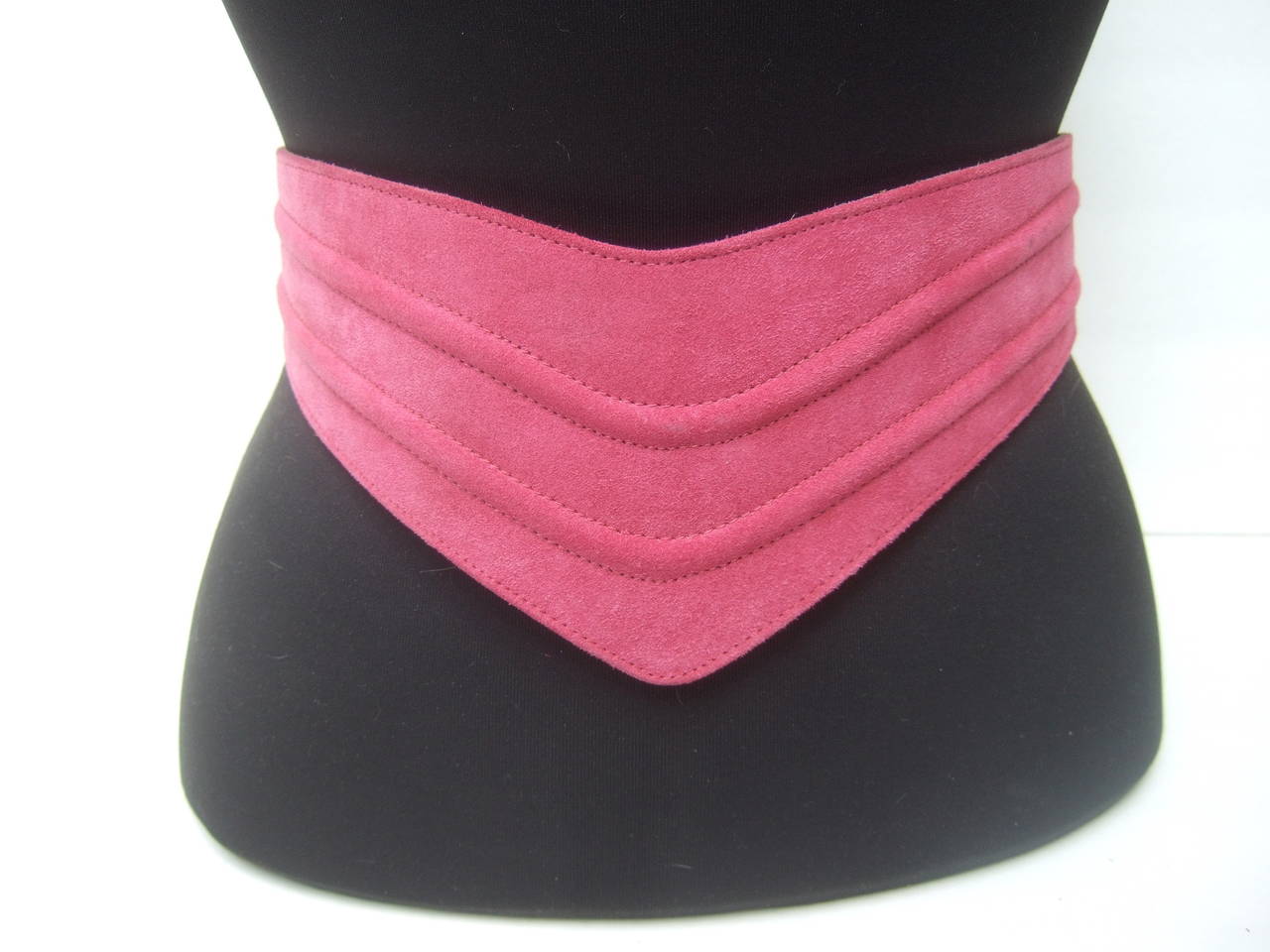 Givenchy Paris Fuchsia suede wide belt c 1980
The stylish belt is designed with plush suede 
with two ribbed bands in a curved sinuous shape 

The front of the designer belt is the widest
section & the sides taper & narrows
The interior