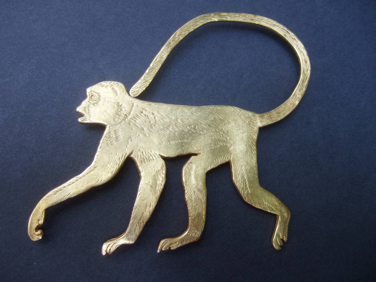 Avant-garde huge gilt metal monkey brooch c 1990
The unique matte gilt metal monkey brooch is 
accented with etched designs that emulates fur
The large scale figural brooch makes a very 
striking accessory 

The whimsical artisan brooch is