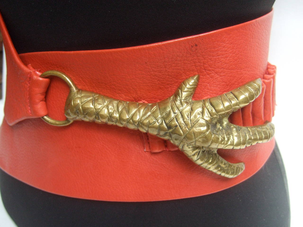 Surrealistic scarlet red leather brass claw belt designed by
Georges Mailian Paris

The spectacular avant-garde belt is adorned with a huge brass 
metal claw. The ornate brass metal claw buckle is substantial in 
weight. The wide supple red