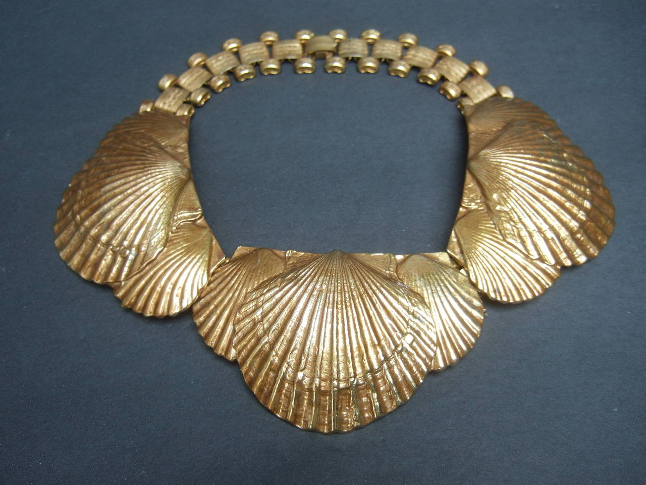 Magnificent gilt metal scallop shell choker necklace c 1940s
The extraordinary necklace is designed with a series 
of gold metal scallop shell medallions in three sections
Attributed to Line Vautrin 

The dramatic shell theme necklace has a