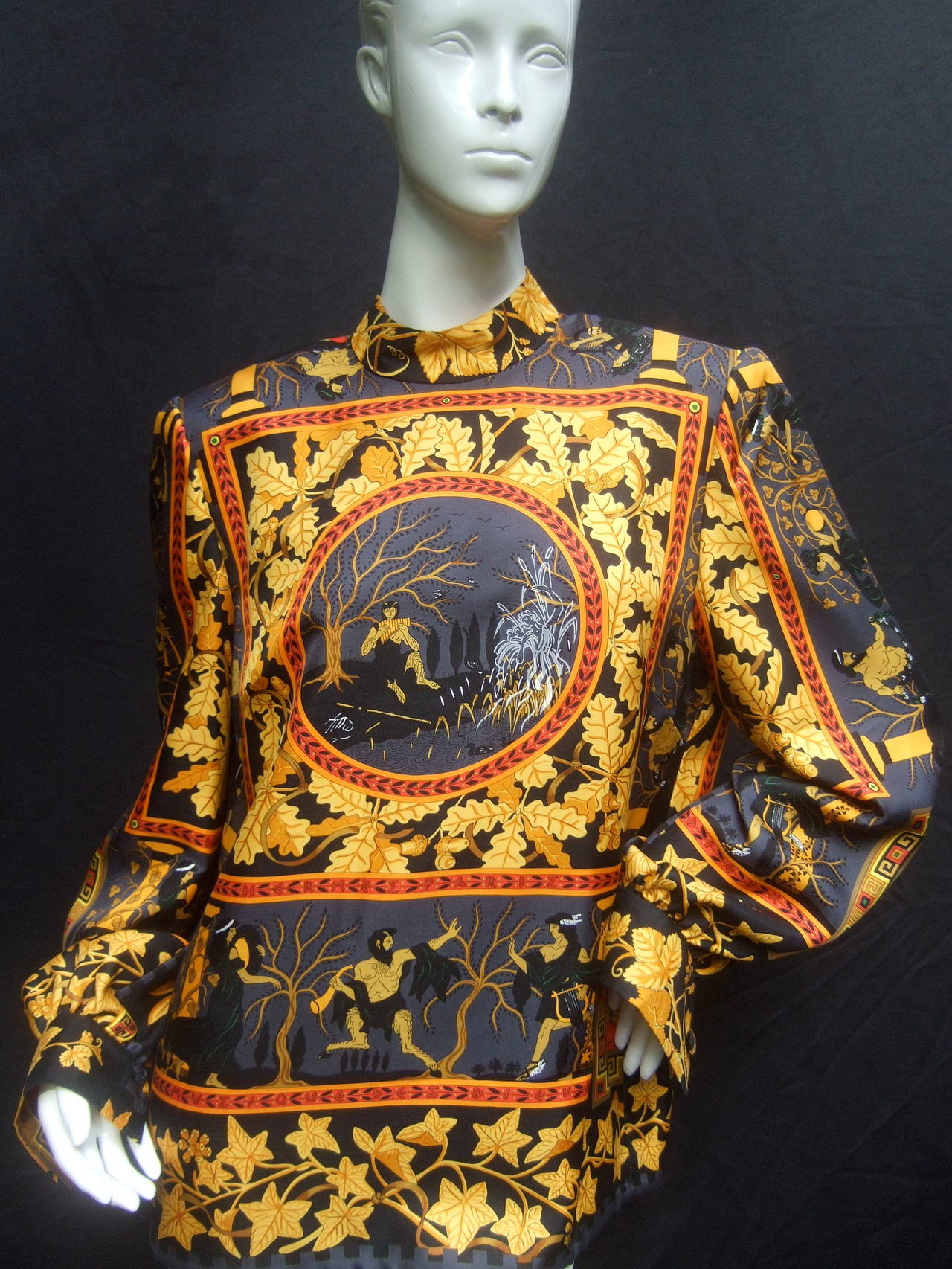 Stunning Hermes mythical Gods of Greece silk blouse c 1980s 
The spectacular Eypine print is illustrated telling the story of the
gods of Greece. The center piece of the extraordinary silk blouse
depicts pan playing his pipes surrounded with oaks
