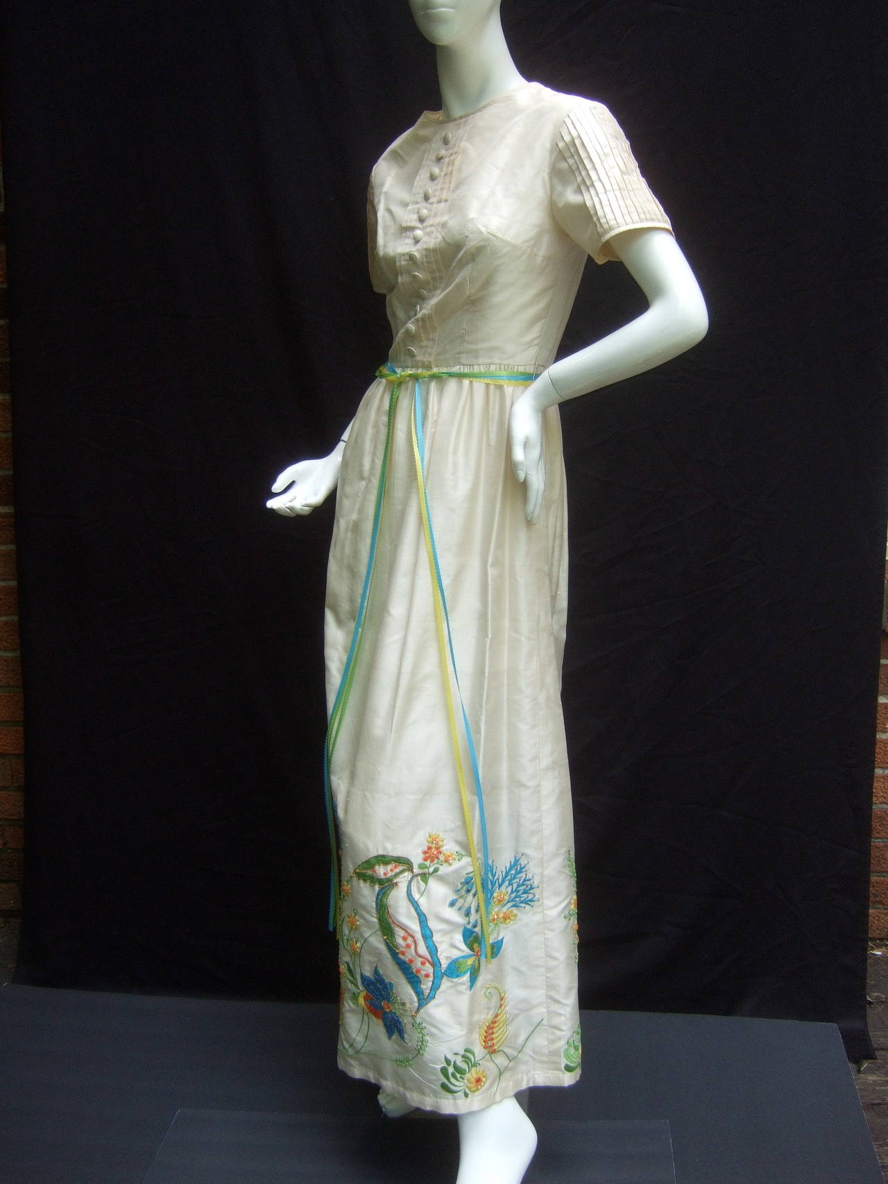 Exotic oyster silk embroidered gown from India for Bonwit Teller c 1970
The elegant vintage silk gown is embellished with elaborate 
floral embroidery that circles the hemline

The intricate embroidered flowers are accented with small
glass beading