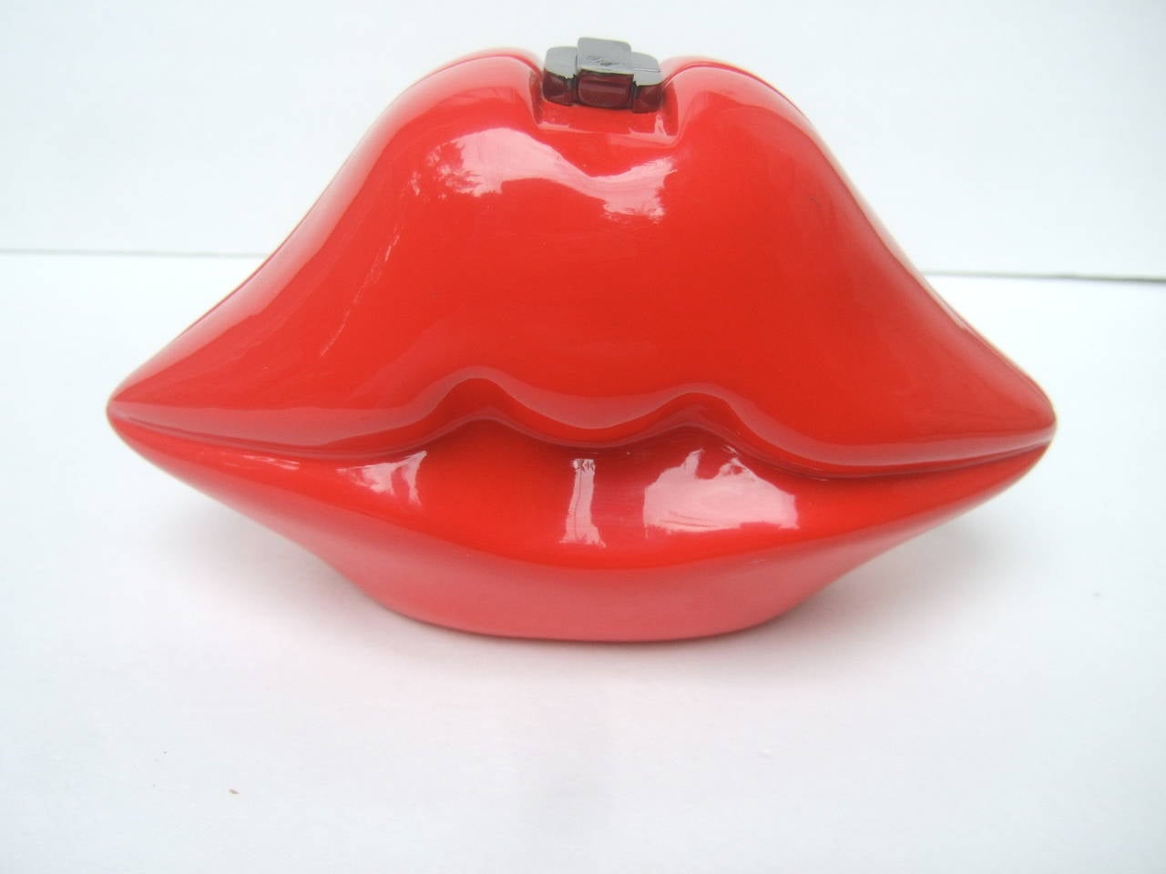 Timmy Woods Beverly Hills luscious red enamel lips handbag
The mod style artisan handbag is designed with hand carved 
wood from fallen acacia tress in the Philippines

The bold puckered lips are lacquered with bright red enamel 
that has a