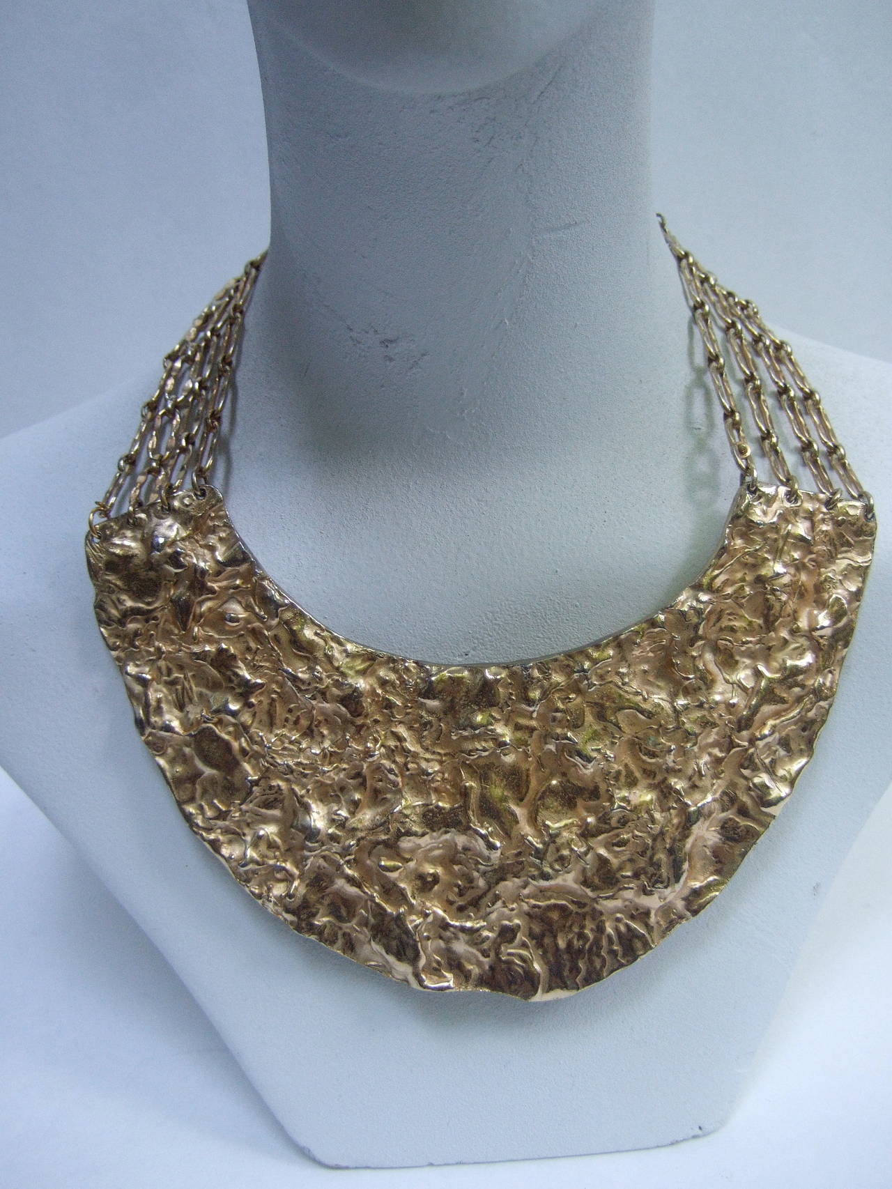 Massive hammered gilt metal collar necklace c 1970
The avant-garde statement necklace is designed 
with a modernist style large scale crescent plate

The center hammered plate is substantial in weight;
is suspended for a series of wide gilt