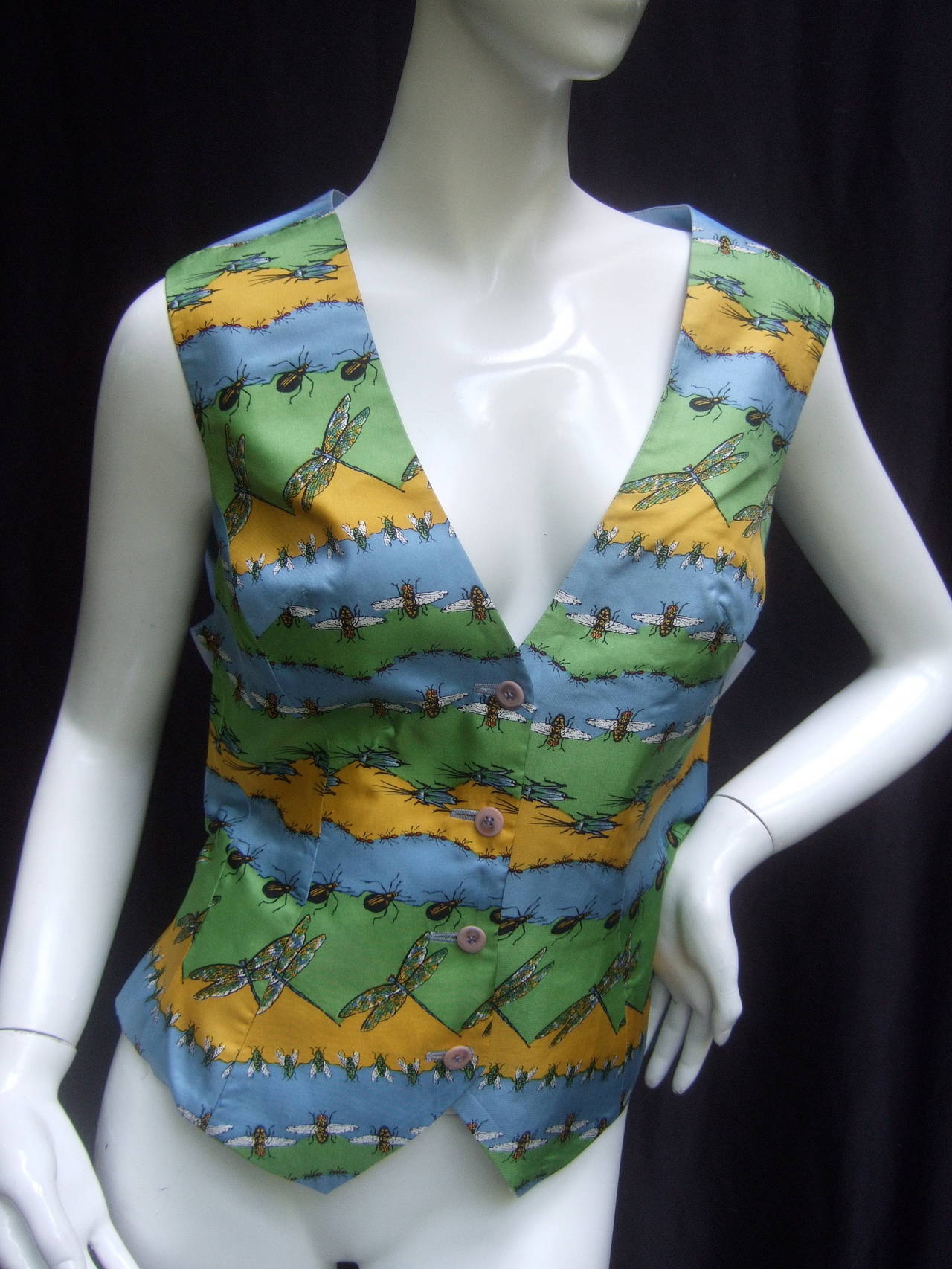 Quirky avant-garde silk insect print women's vest US Size 12
The unique silk vest is illustrated with a collection 
of insects; dragonflies, beetles, flies, bees and 
grasshoppers 

The back side of the whimsical vest is ice blue 
satin