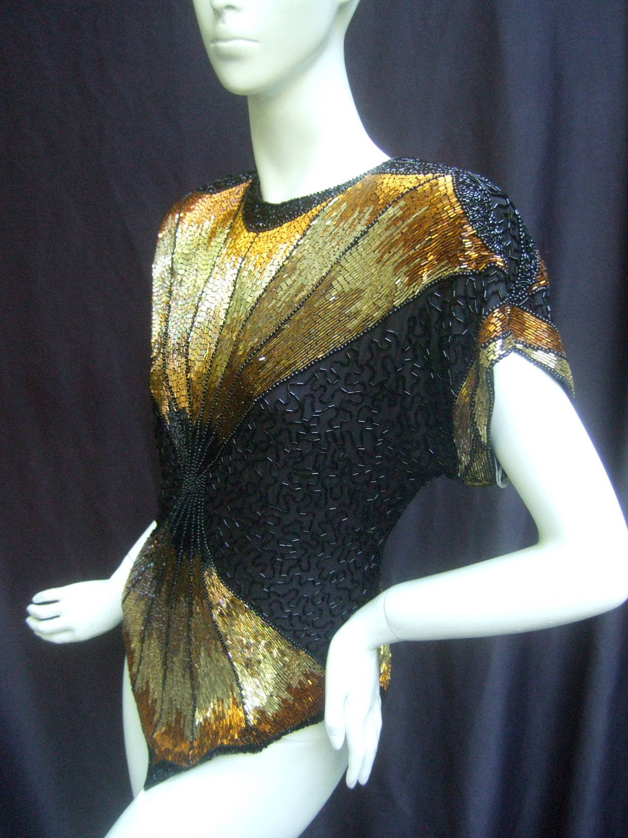Oleg Cassini Lavish silk beaded top Size small 
The dramatic show stopping silk top is embellished
with elaborate beading in golden bronze metallic hues

The glittering bugle beads are intricately designed
in mosaic of radiating beams; in a