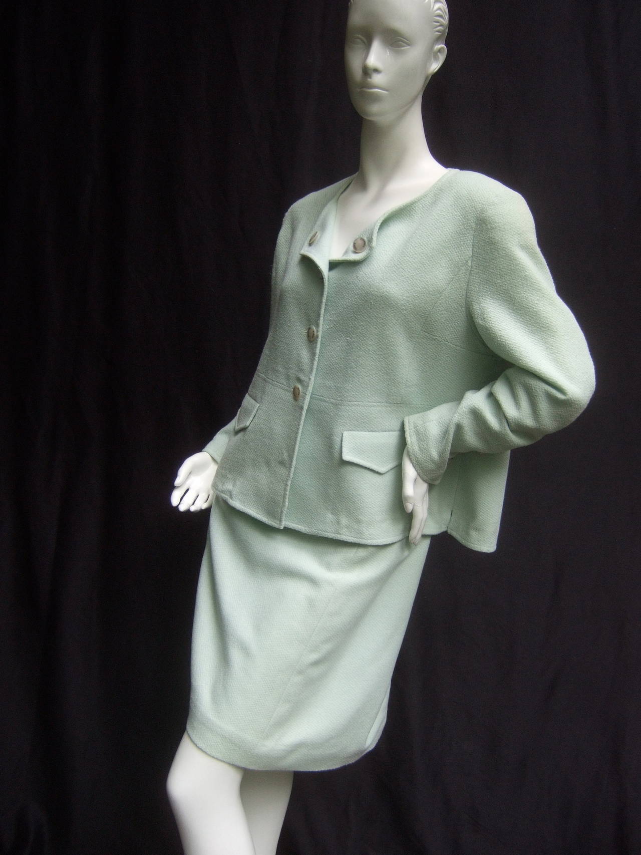 Chanel Boutique Chic mint green wool skirt suit c 1990
The classic pale green skirt suit is adorned with five
mother of pearl buttons on the front of the jacket
Each button is stamped Chanel Paris 

Each sleeve is designed with three matching