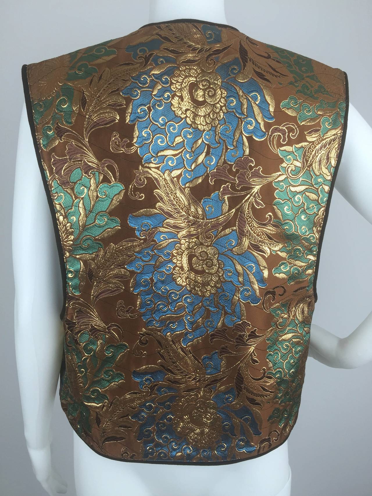 Late 1960's Camerino brocaded vest of metallic gold thread on quilted satin.  Lined in brown velvet.  Deeply cut sleeves.  

Simple clean lines allow the luxurious, Asian inspired, decoration to take center stage.  

Closes with her signature