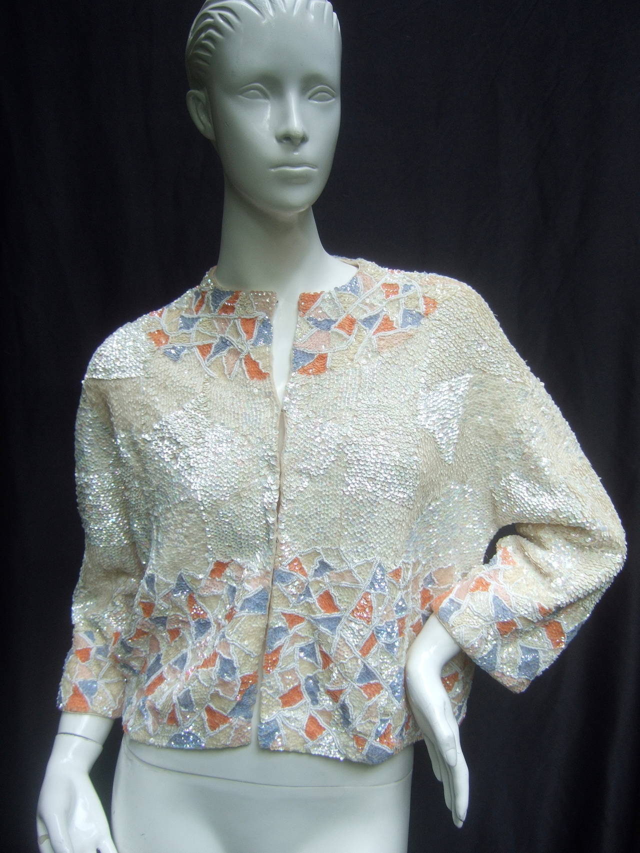 Extravagant sequined & beaded iridescent cardigan c 1960
The hand sequined cardigan is a mosaic of contiguous
glittering ivory & pastel embellishments 

The collar yoke, cuffs & borders are encrusted 
with pastel lavender, pale pink & coral