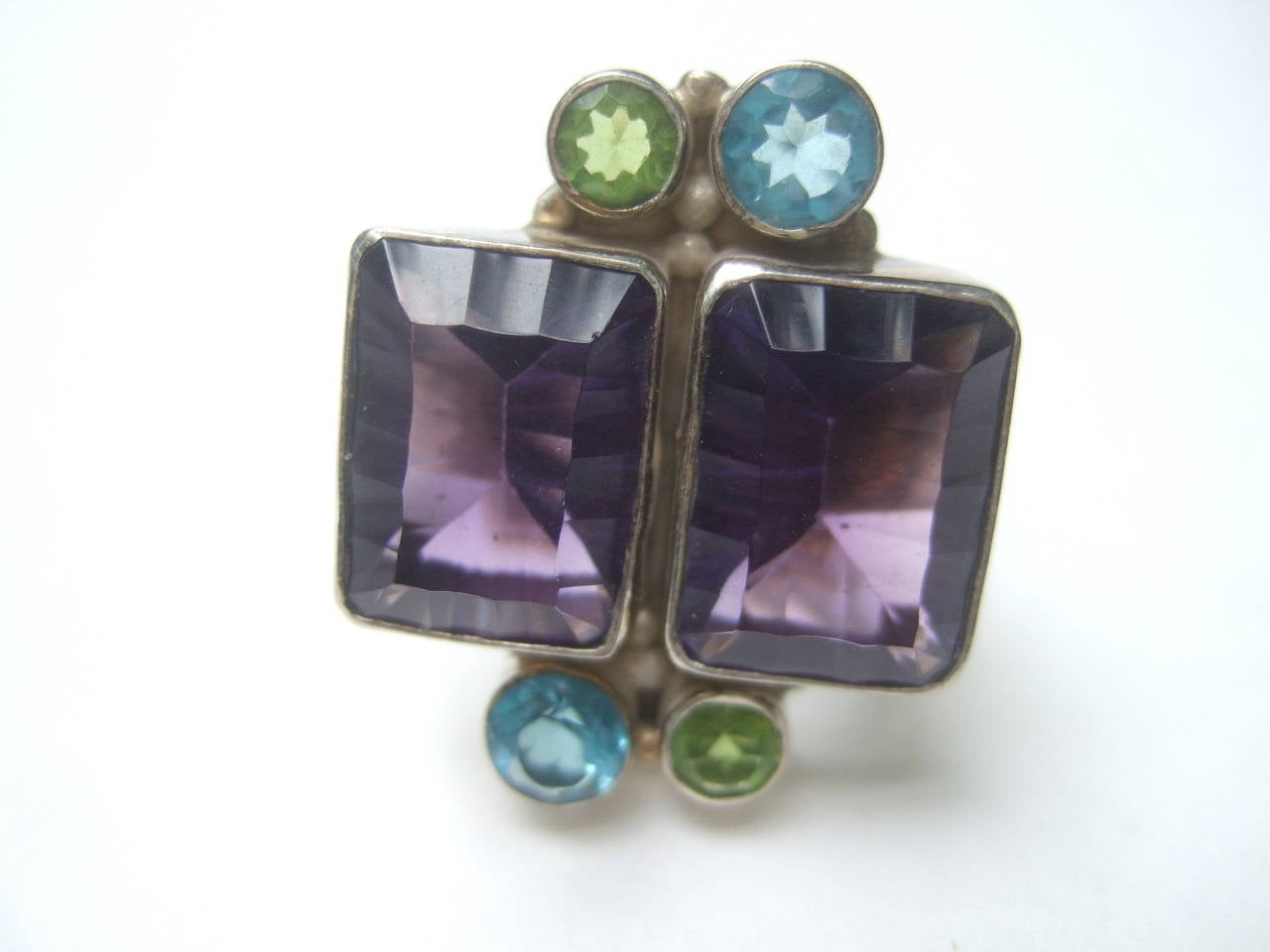 Sterling artisan semi precious amethyst ring Size 8.5
The large scale cocktail style ring is designed 
with two large rectangular amethyst bezel set
crystals

On both sides of the center amethyst settings
are smaller circular aquamarine and