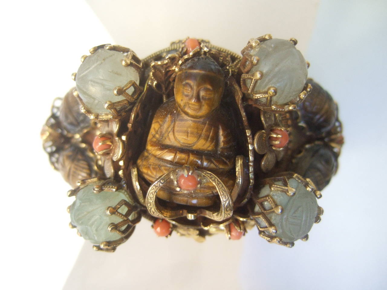 Exotic carved tiger eye jeweled Buddha beetle bracelet  
The unique Asian style gilt cuff bracelet is adorned with 
a semi precious tiger eye carved Buddha figure
at the center 

The Buddha figure is surrounded by two carved 
tiger eye beetles