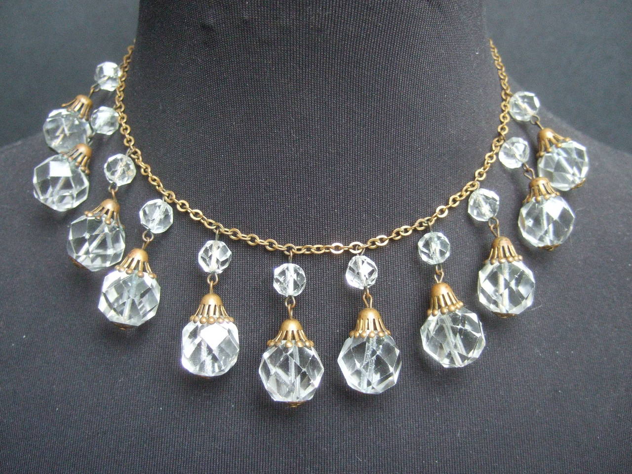 Opulent Art Deco crystal drop chain necklace c 1940s
The elegant necklace is embellished with brilliant faceted 
crystals that dangle from a delicate brass metal chain 

The tiered graduated crystals create a beautiful romantic design
The brass