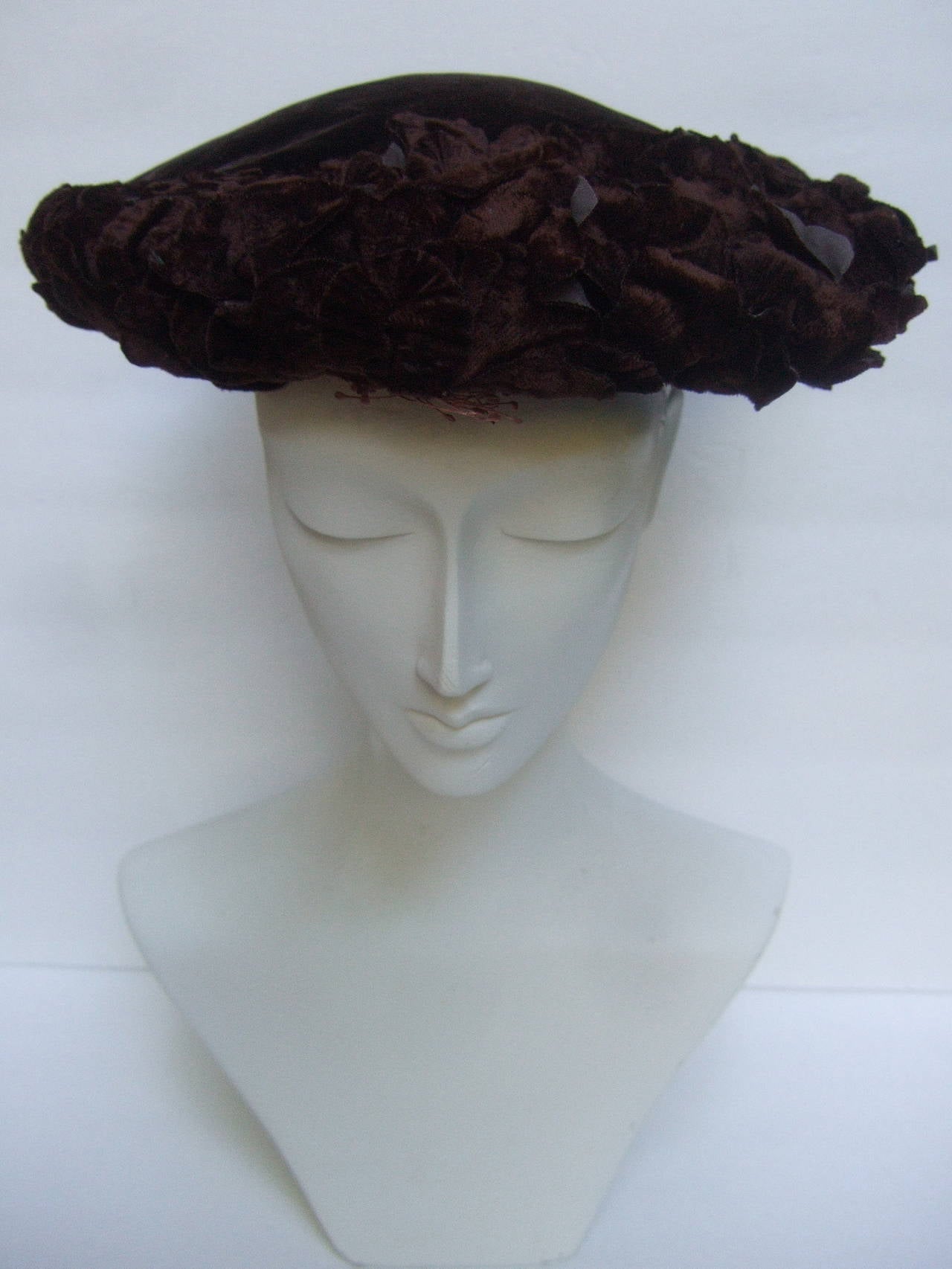 Brown velvet flower pedal hat for Neiman Marcus Made in Italy 
The stylish pancake style hat is designed with with plush
dark brown velvet. The handmade design is embellished 
with brown felt applique leaves that circle the edges 

The Italian