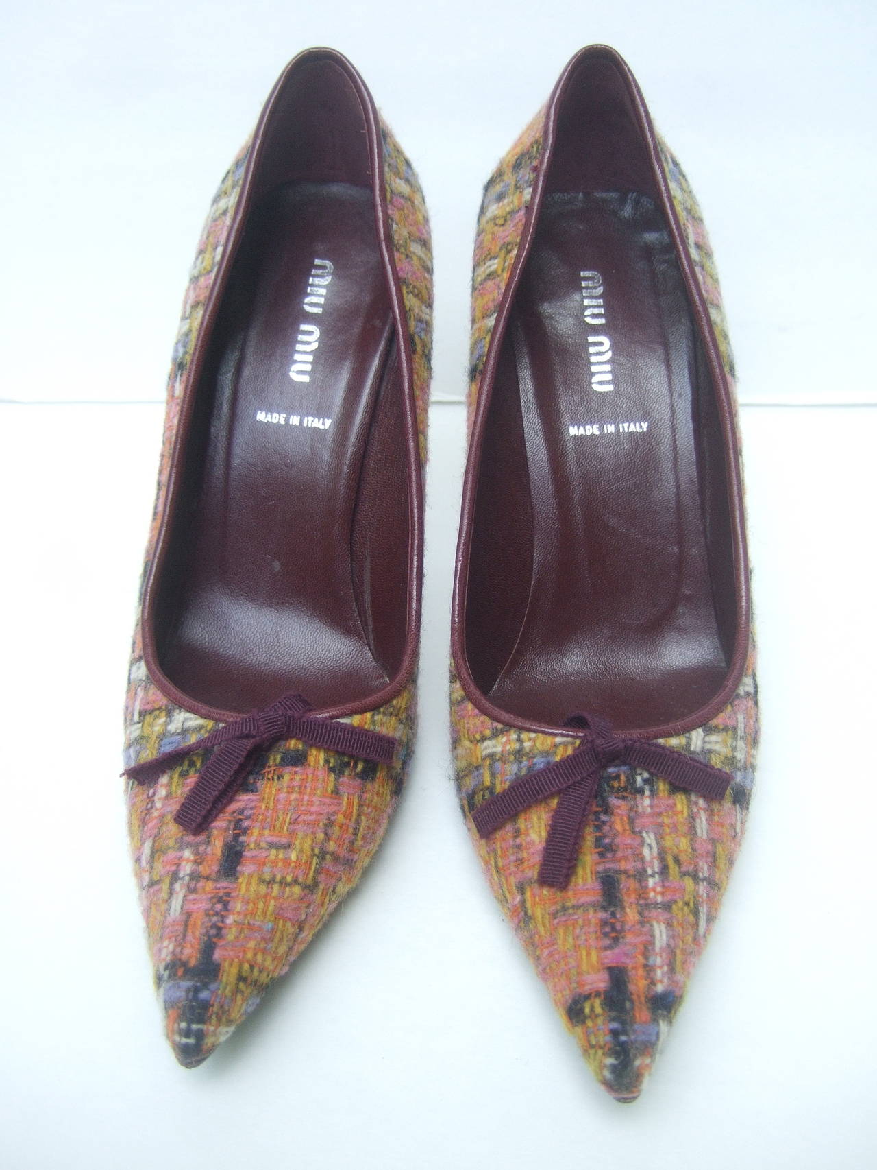 Miu Miu Plaid wool pumps Made in Italy Size 38
The stylish designer pointed toe pumps are covered
with plaid wool with groisgrain burgundy ribbon bows

The plaid wool covering is blended with pink, yellow,
orange, lavender with streaks of